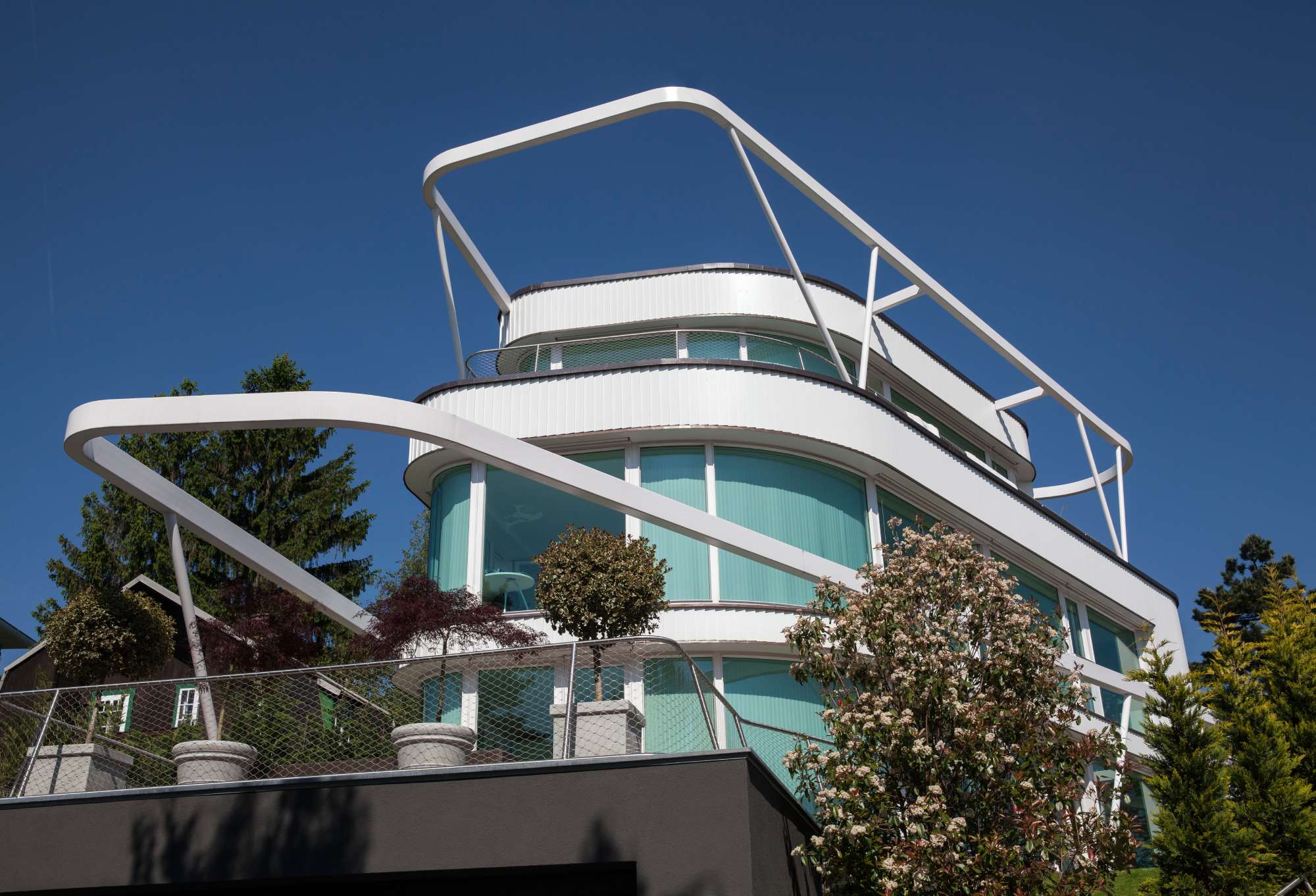 Frontale Ansicht des Gebäudes mit markanten weißen Bögen und klarer Linienführung.