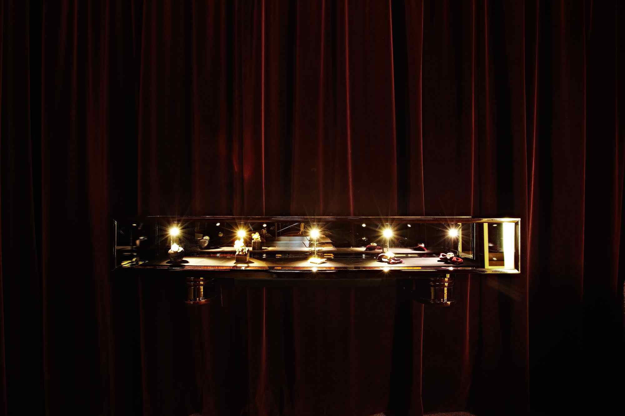 Dunkler Raum mit horizontal beleuchteter Schmuckpräsentation.