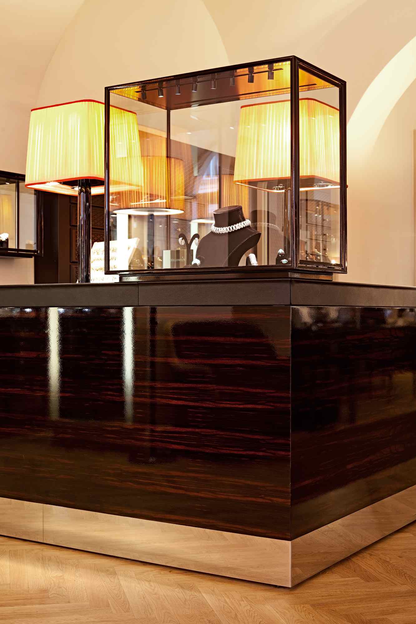 Eleganter Tresen mit Vitrine und warmem Licht im Eingangsbereich.