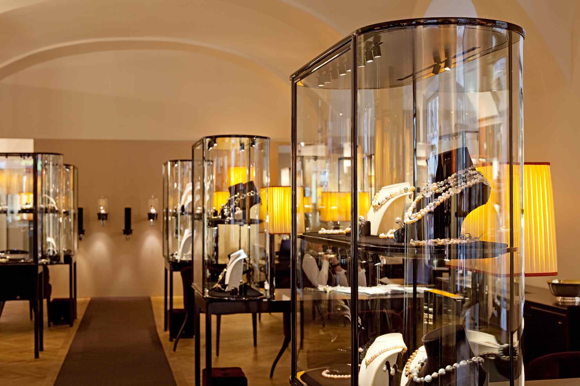 Blick durch eine Abfolge gewölbter Räume mit beleuchteten Vitrinen.