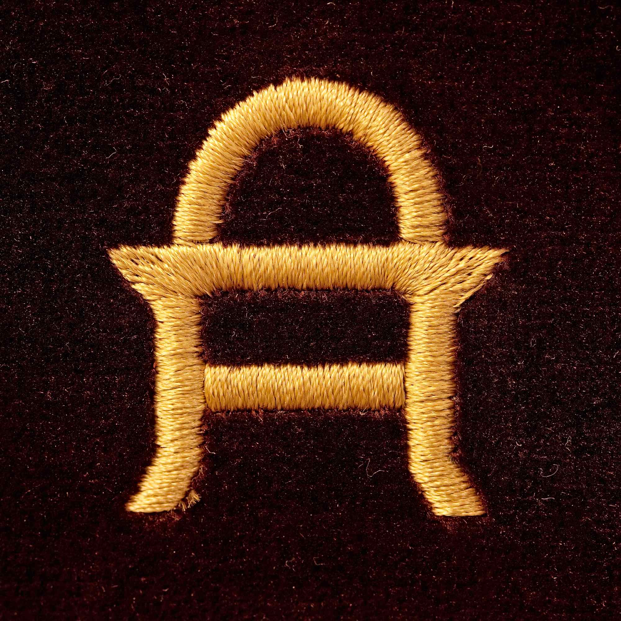 Goldenes Logo in Form eines stilisierten „H“ auf dunklem Hintergrund.