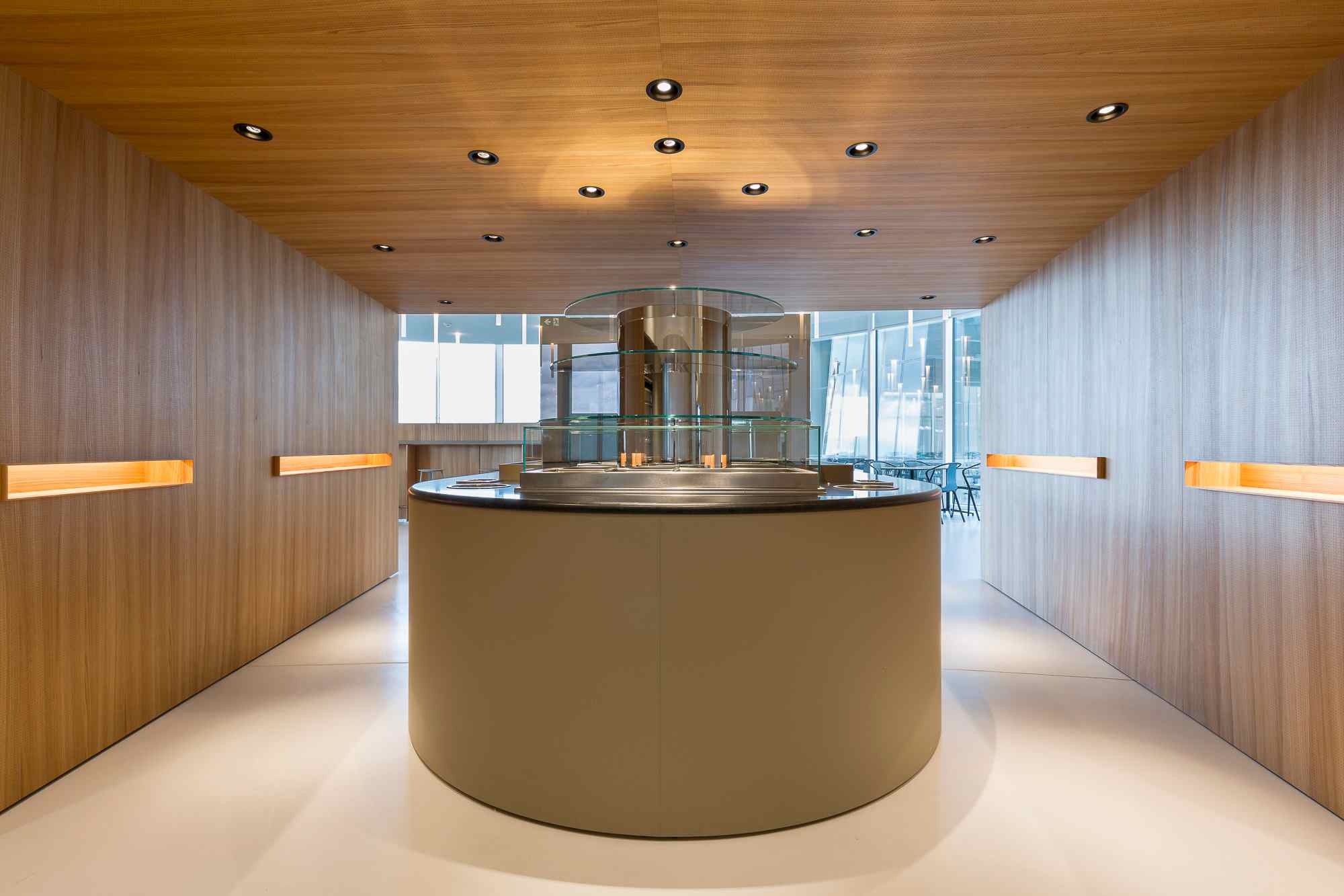 Zentrale Ausgabeinsel mit Holzverkleidung und Tageslicht