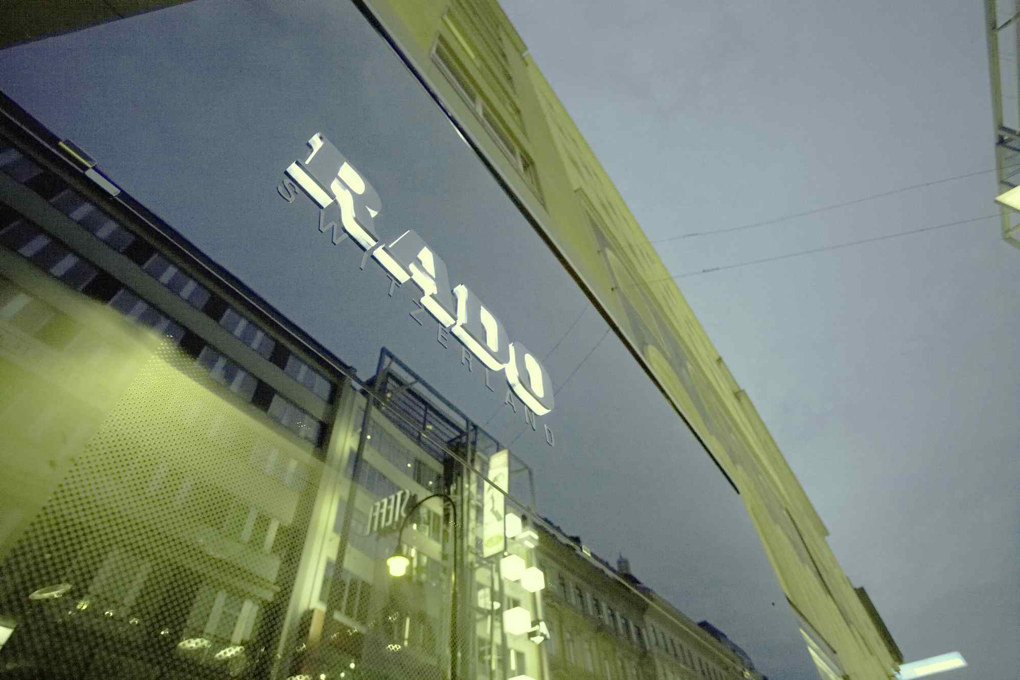 Schräger Blick auf RADO-Schriftzug an Glasfassade