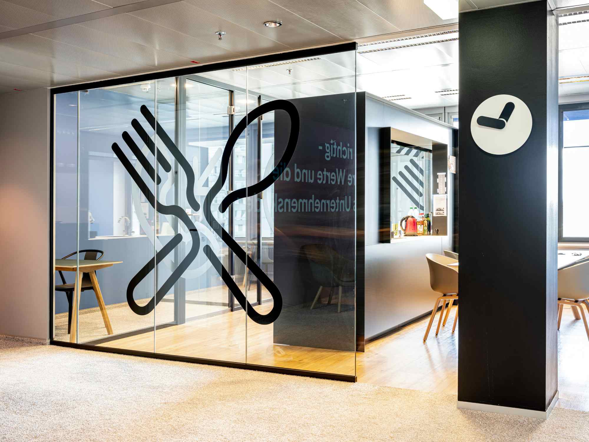 Eingang zum Essbereich mit grafischem Wanddesign und Uhrensymbol