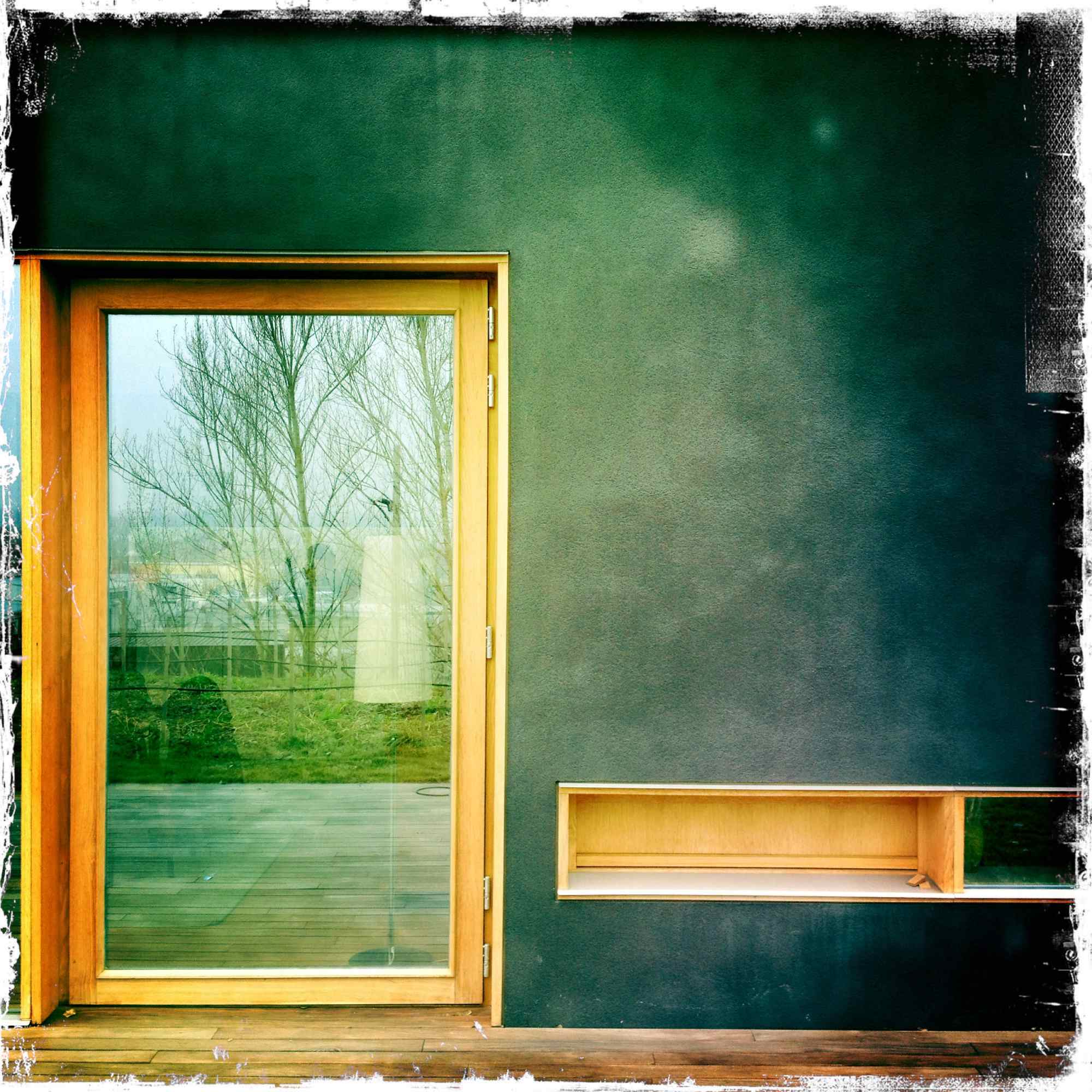 Detailaufnahme einer Tür mit Holzrahmen und Glasfläche