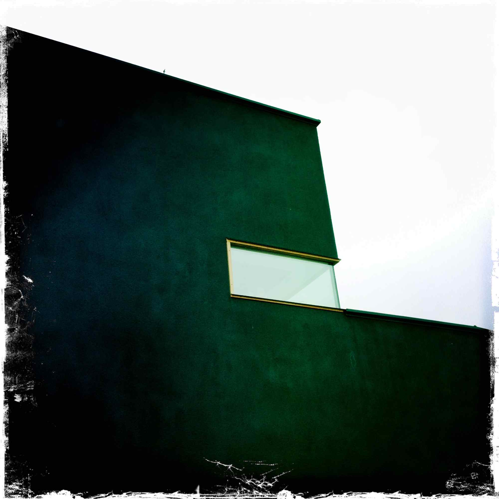 Minimalistische schwarze Fassade mit schmalem Fensterband