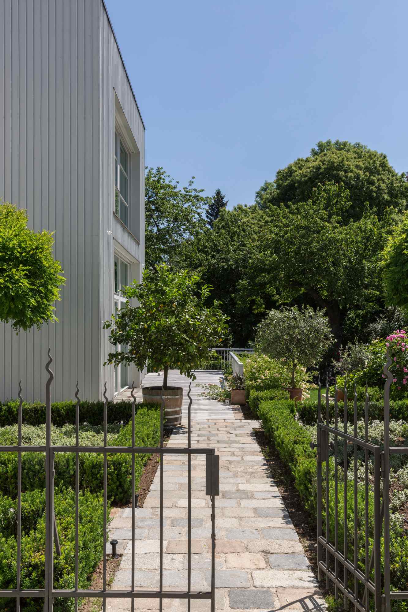 Gartenweg mit Bepflanzung entlang der Hausfassade