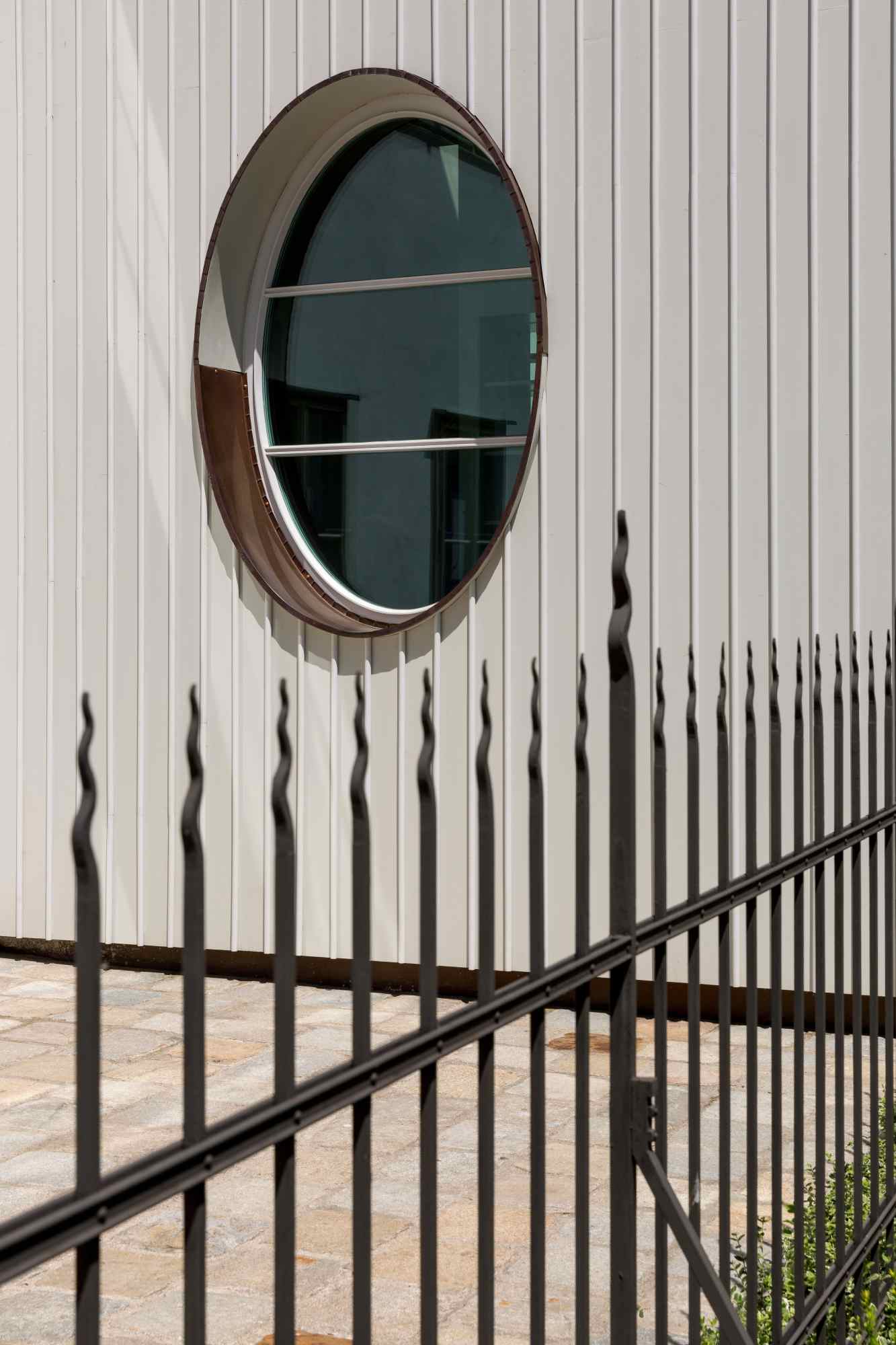 Rundes Fenster mit Schattenwurf eines Zauns