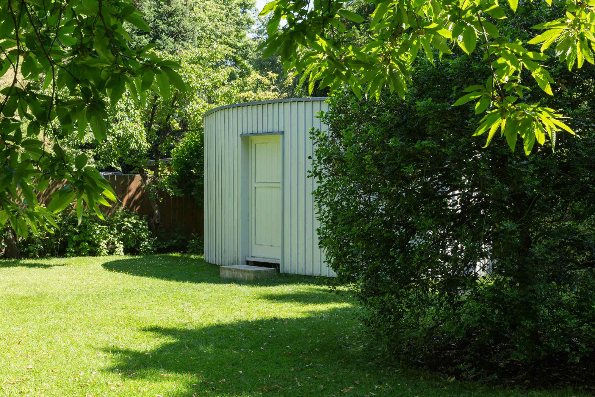 Gartenhaus im Grünen unter schattigen Bäumen