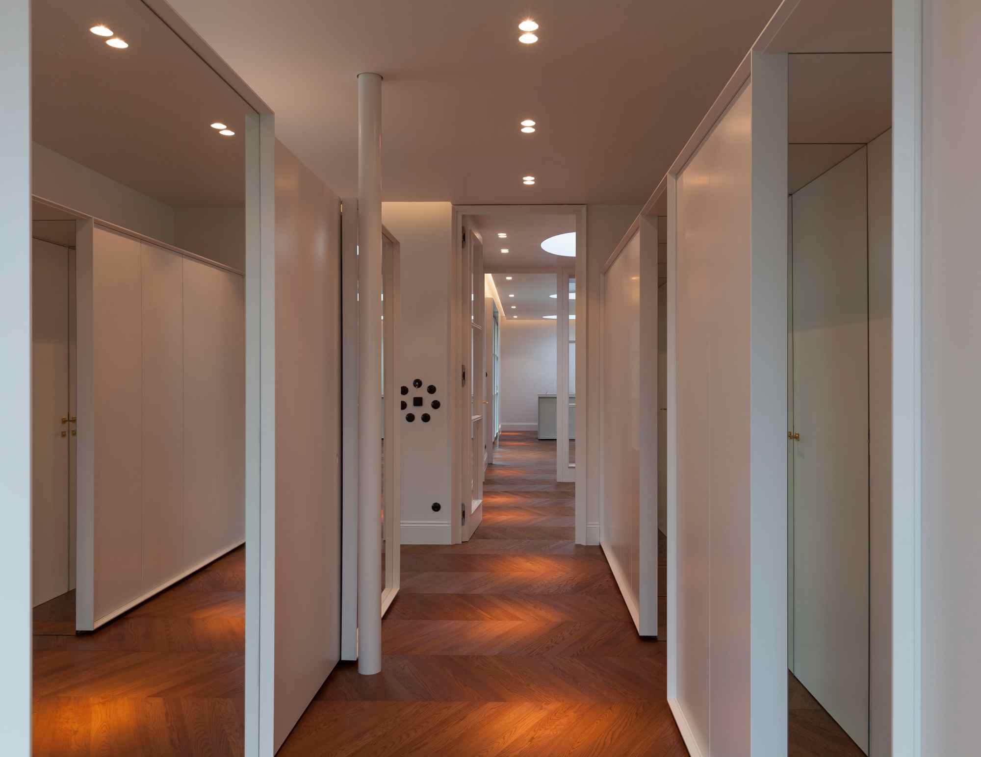 Langer Flur mit weißen Wänden und Holzfußboden