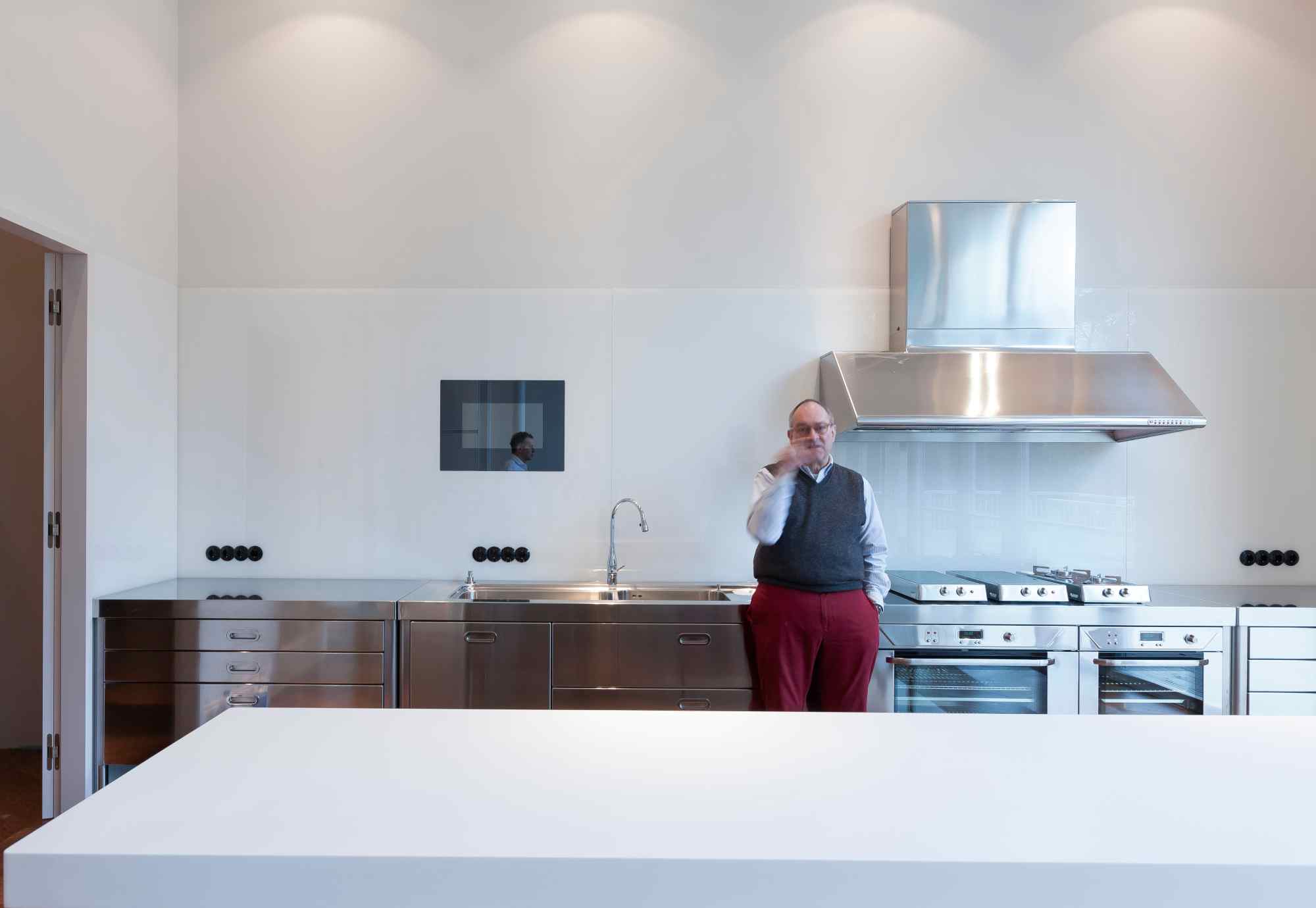 Moderne Küche mit Kochinsel und Person in Rot