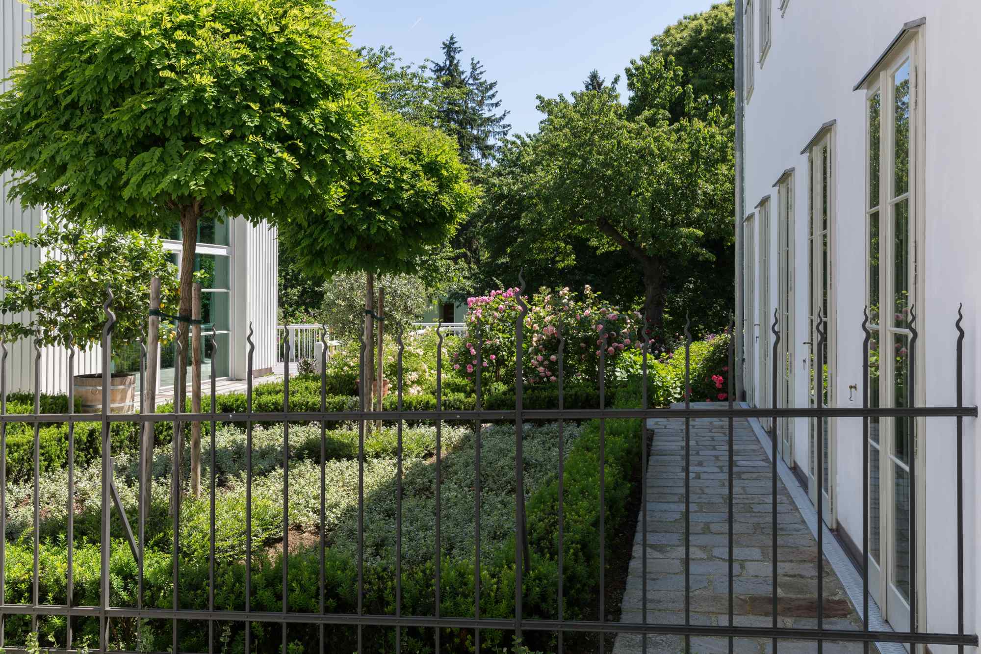 Seitlicher Blick durch Zaun auf Terrasse und Pflanzen