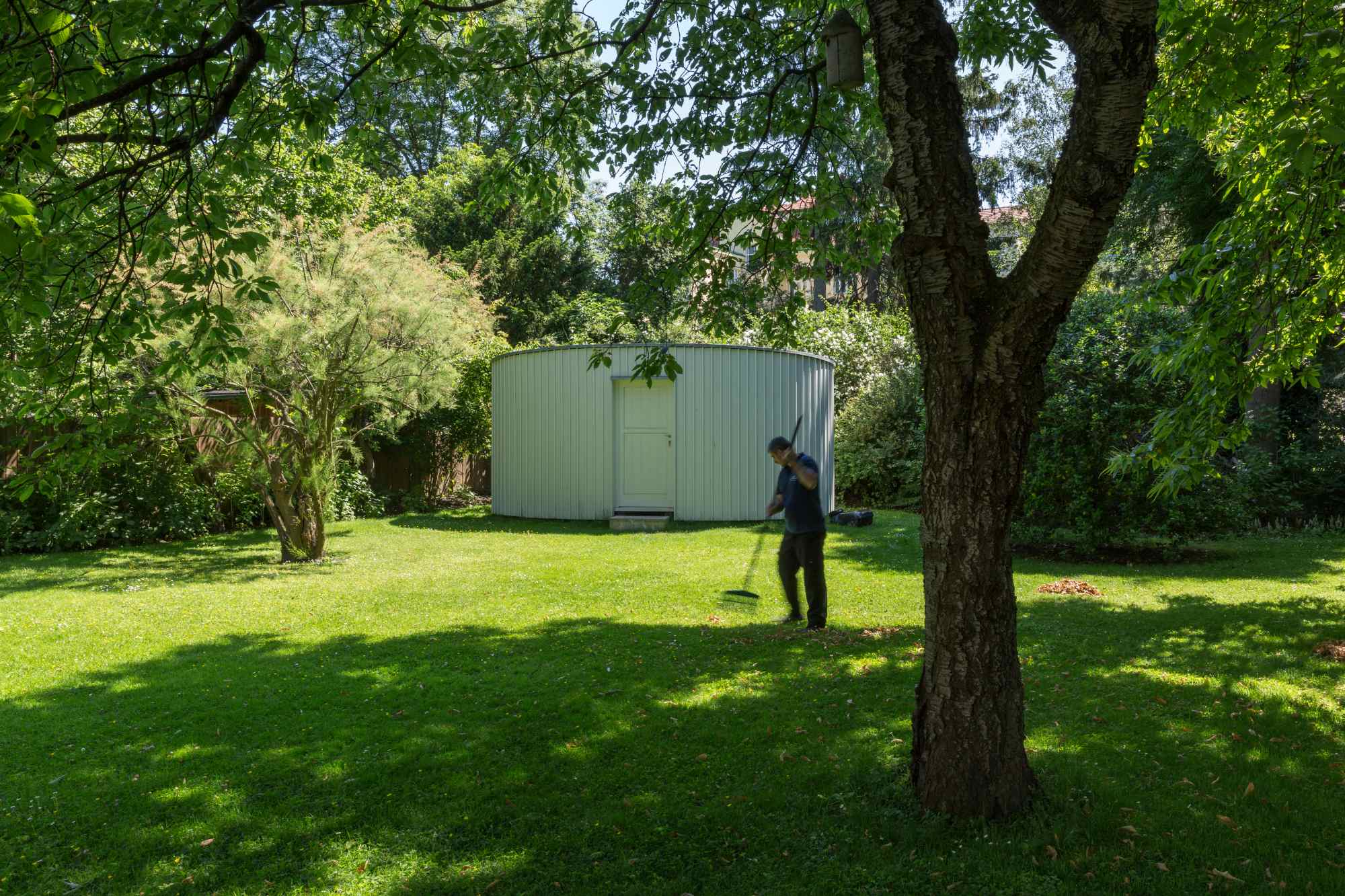 Große Rasenfläche mit Gartenhaus und Person