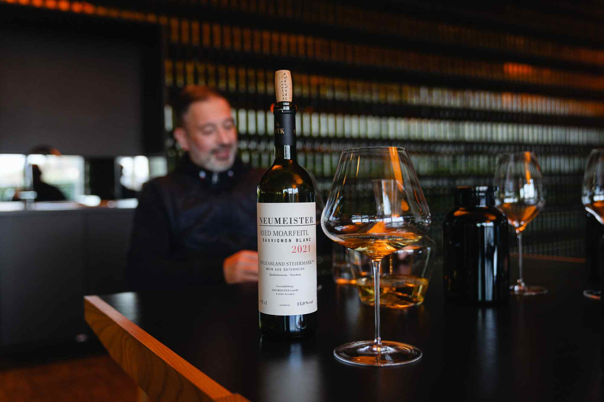 Winzer oder Sommelier bei einer Verkostung am Tisch mit Neumeister-Wein