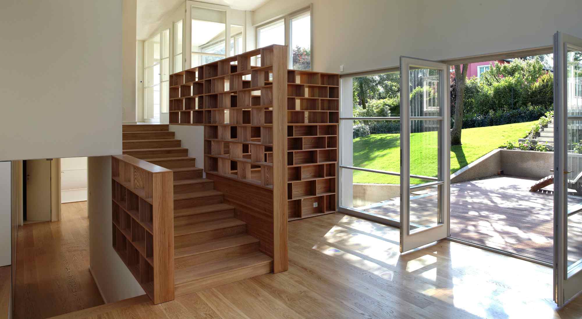 Innenansicht mit Treppe, Lichtspiel und Blick in den Garten