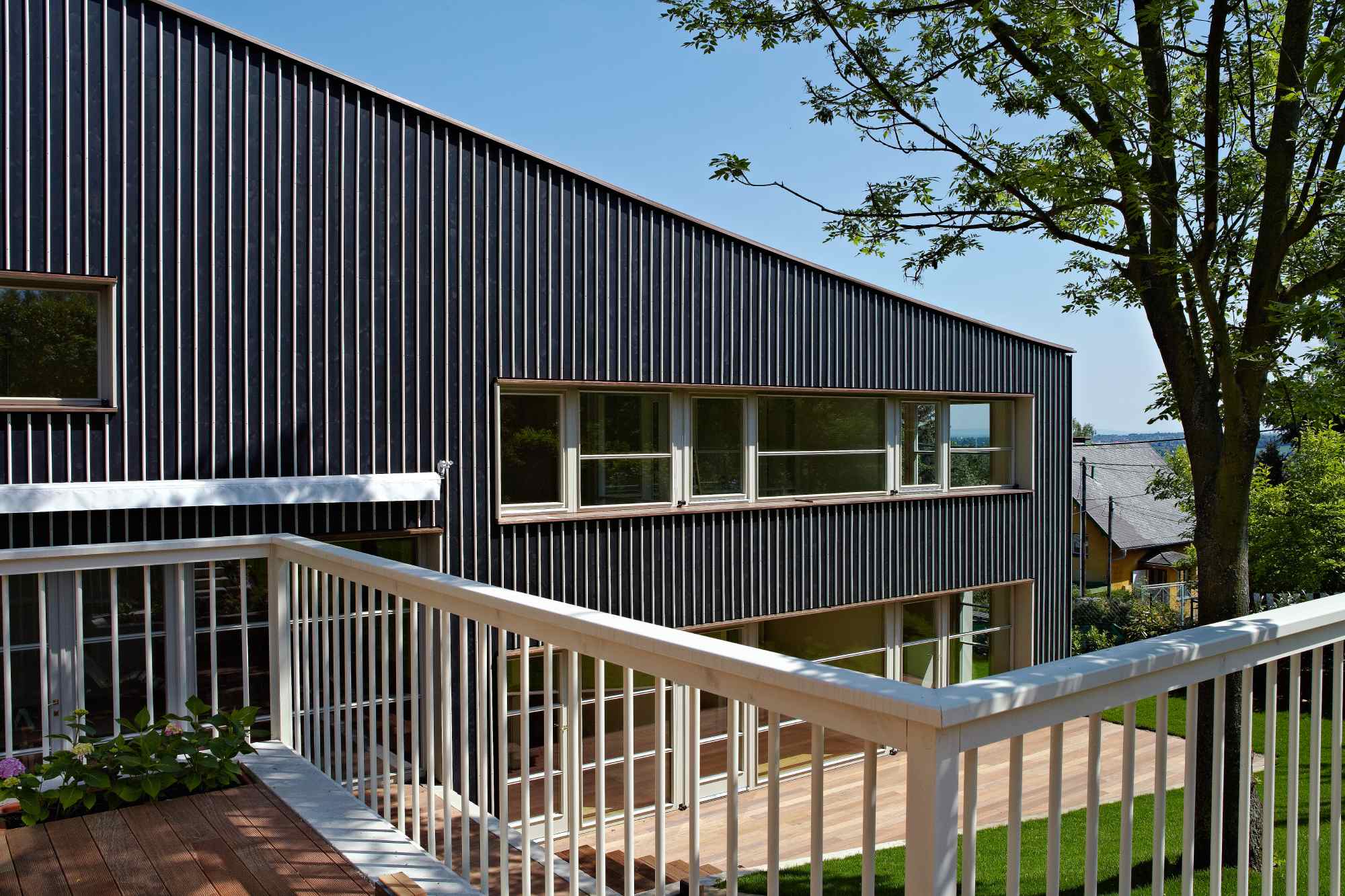 Panoramaansicht mit Balkon, Baum und gestaffelter Fassade