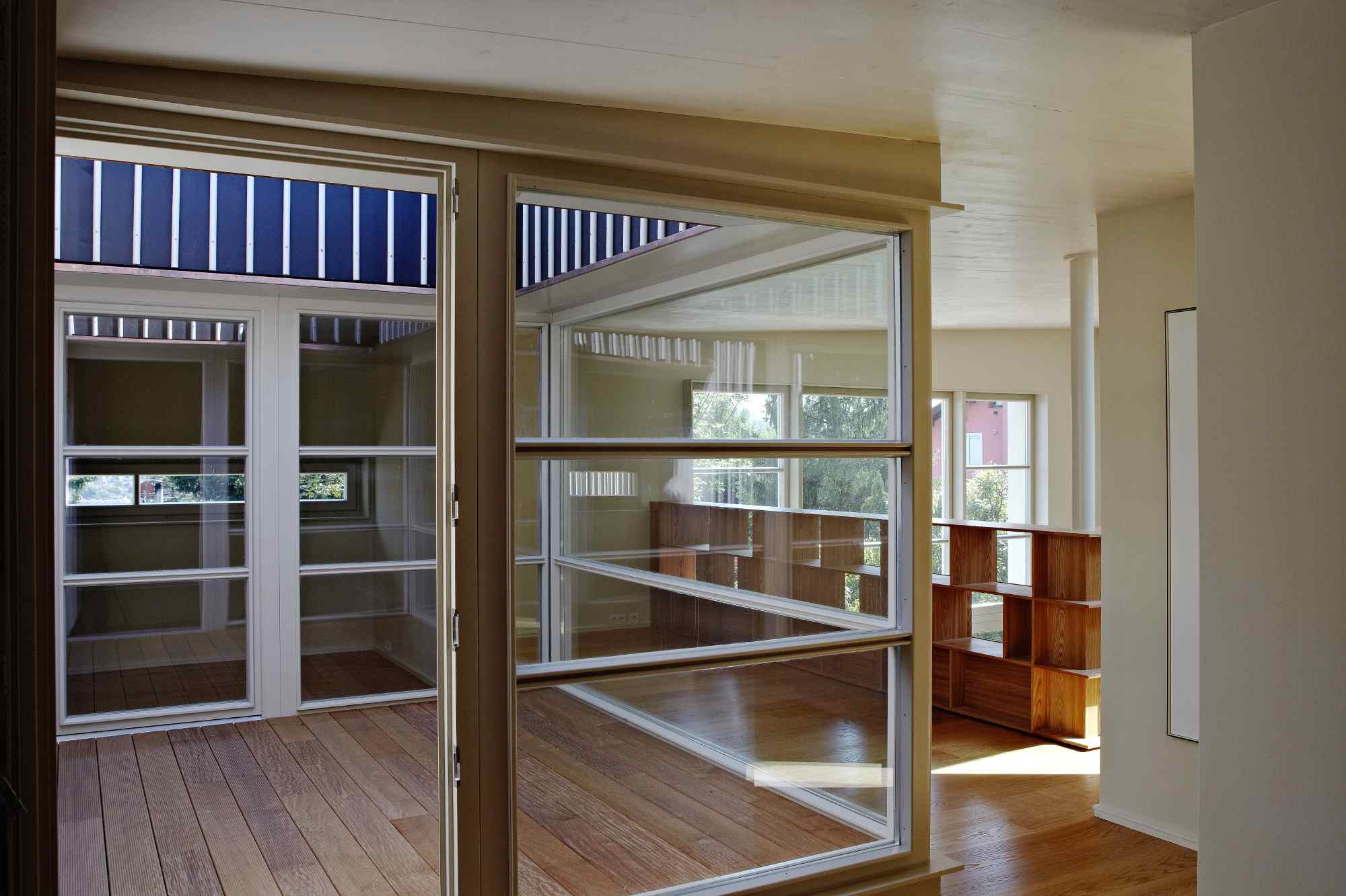 Lichtdurchfluteter Innenraum mit Holzgeländer und Panoramafenster