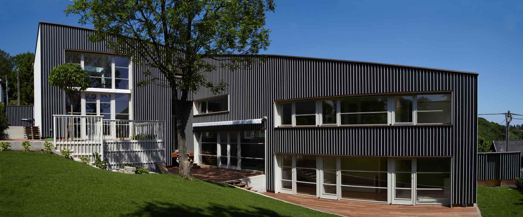 Gesamtansicht der Rückseite mit geschwungener Fassade und Garten