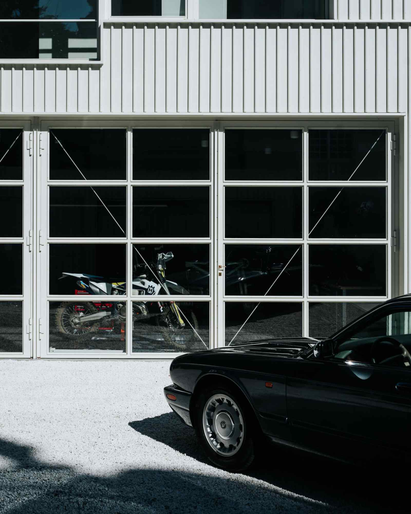 Garage mit schwarzem Oldtimer vor moderner Fassade