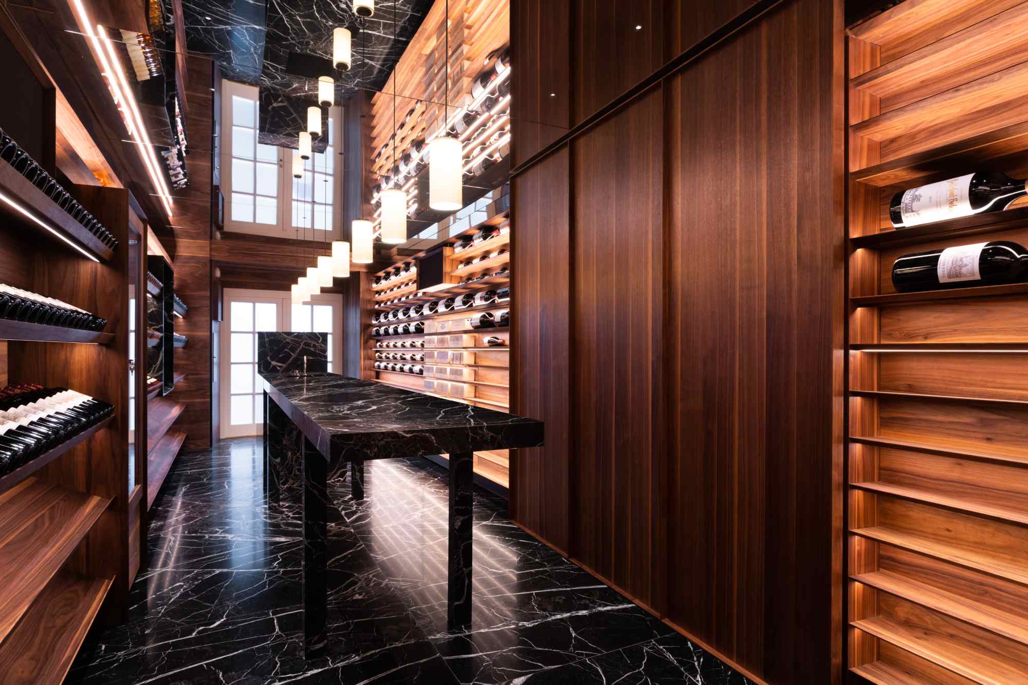 Langer, schmaler Weinkeller mit hoher Regalwand und dunklem Boden