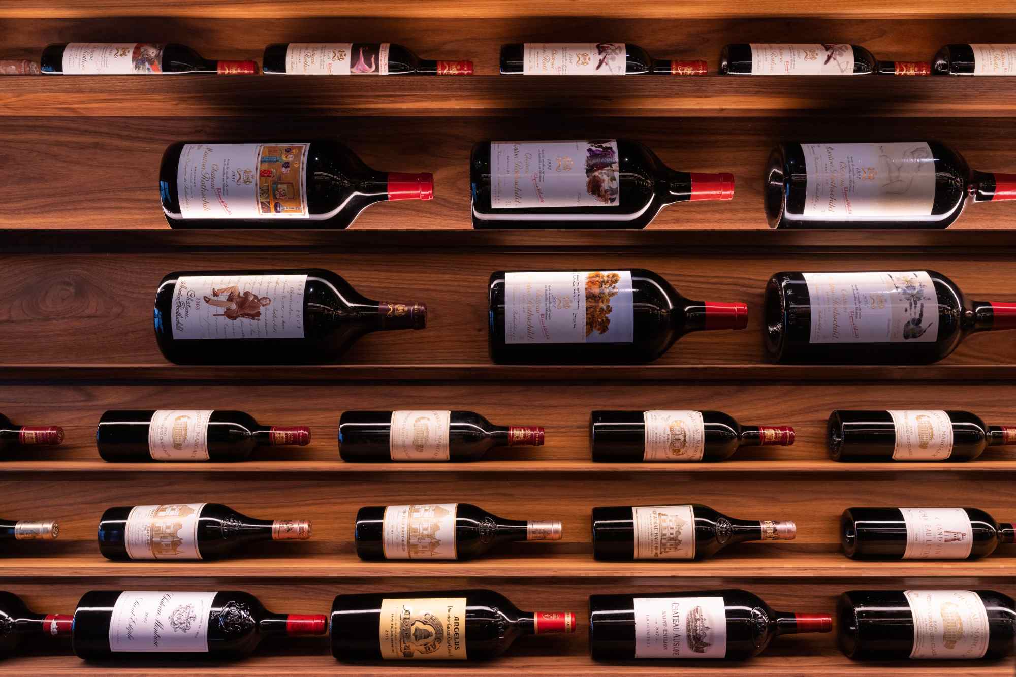 Frontale Ansicht eines Regals mit liegenden Weinflaschen