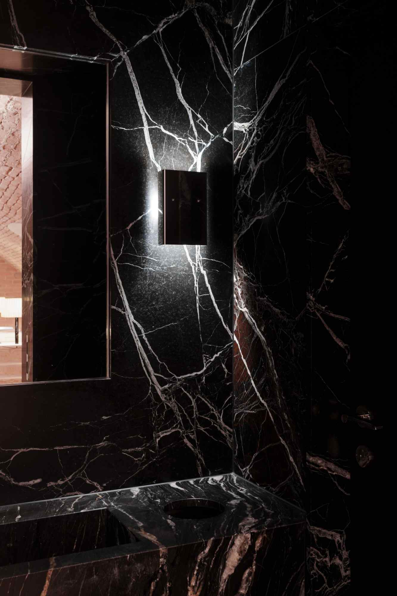 Spiegelwand mit reflektierendem Marmor und indirekter Beleuchtung