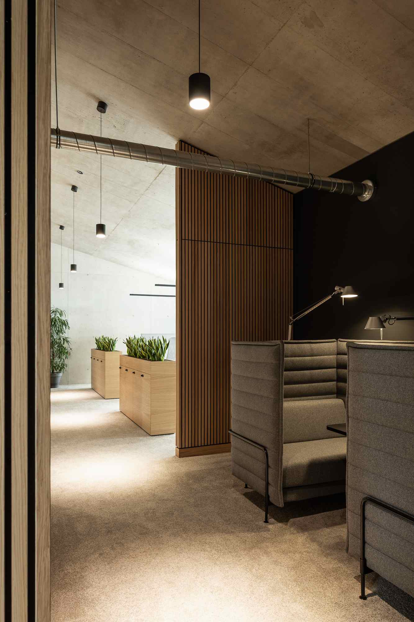 Ruhige Arbeitsnische mit schräger Decke, natürlicher Beleuchtung und Holzmöbeln.