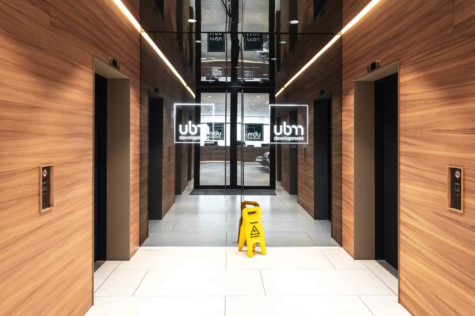 Aufzugslobby mit Holzverkleidung.