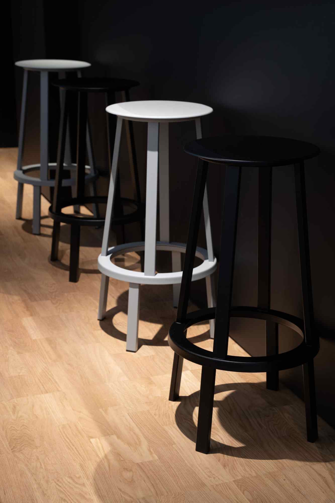 Schwarze und weiße Hocker auf Holzboden.