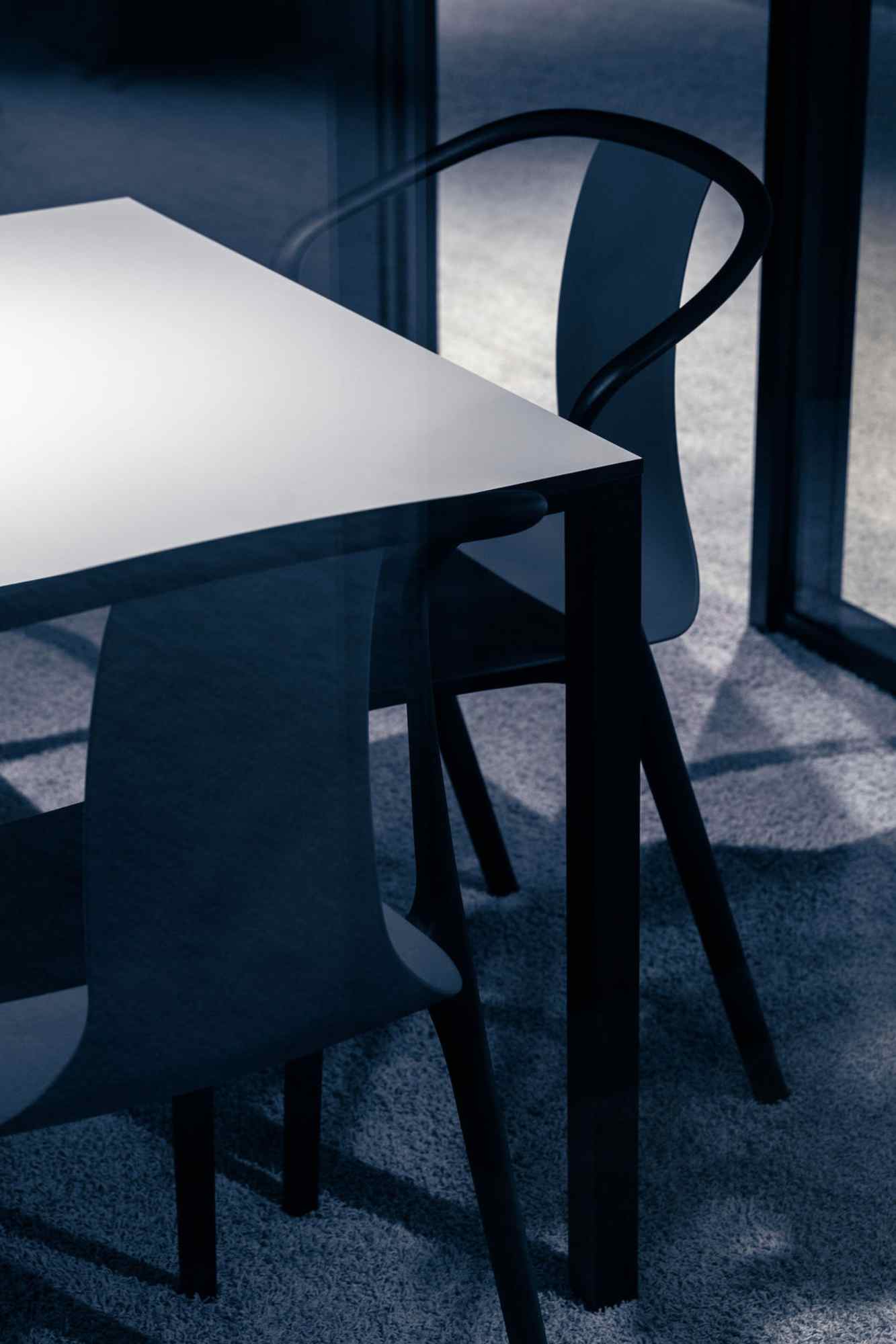 Dunkler Tisch mit schwarzem Stuhl.