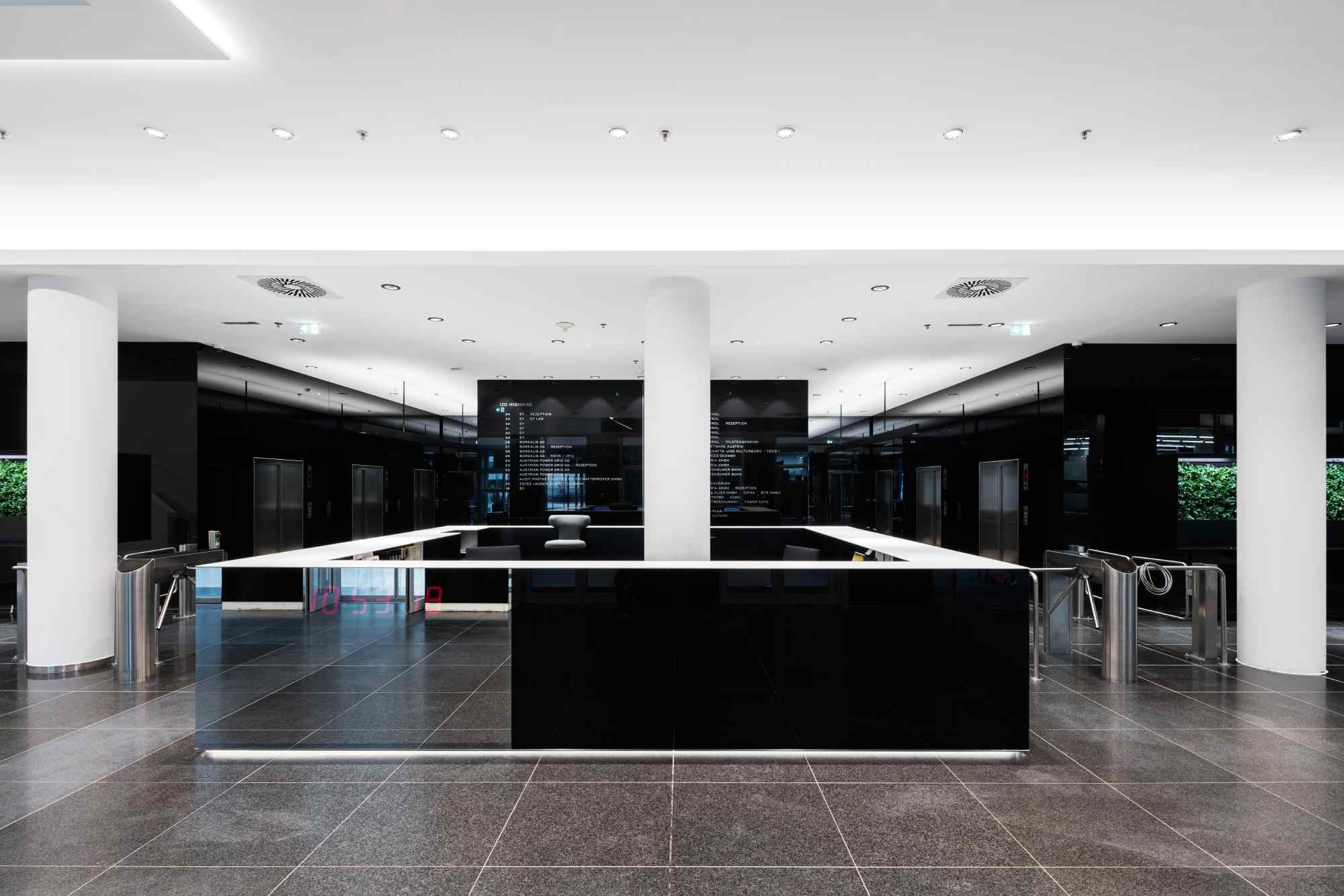 Schwarzer Empfangstresen mit weißen Säulen.