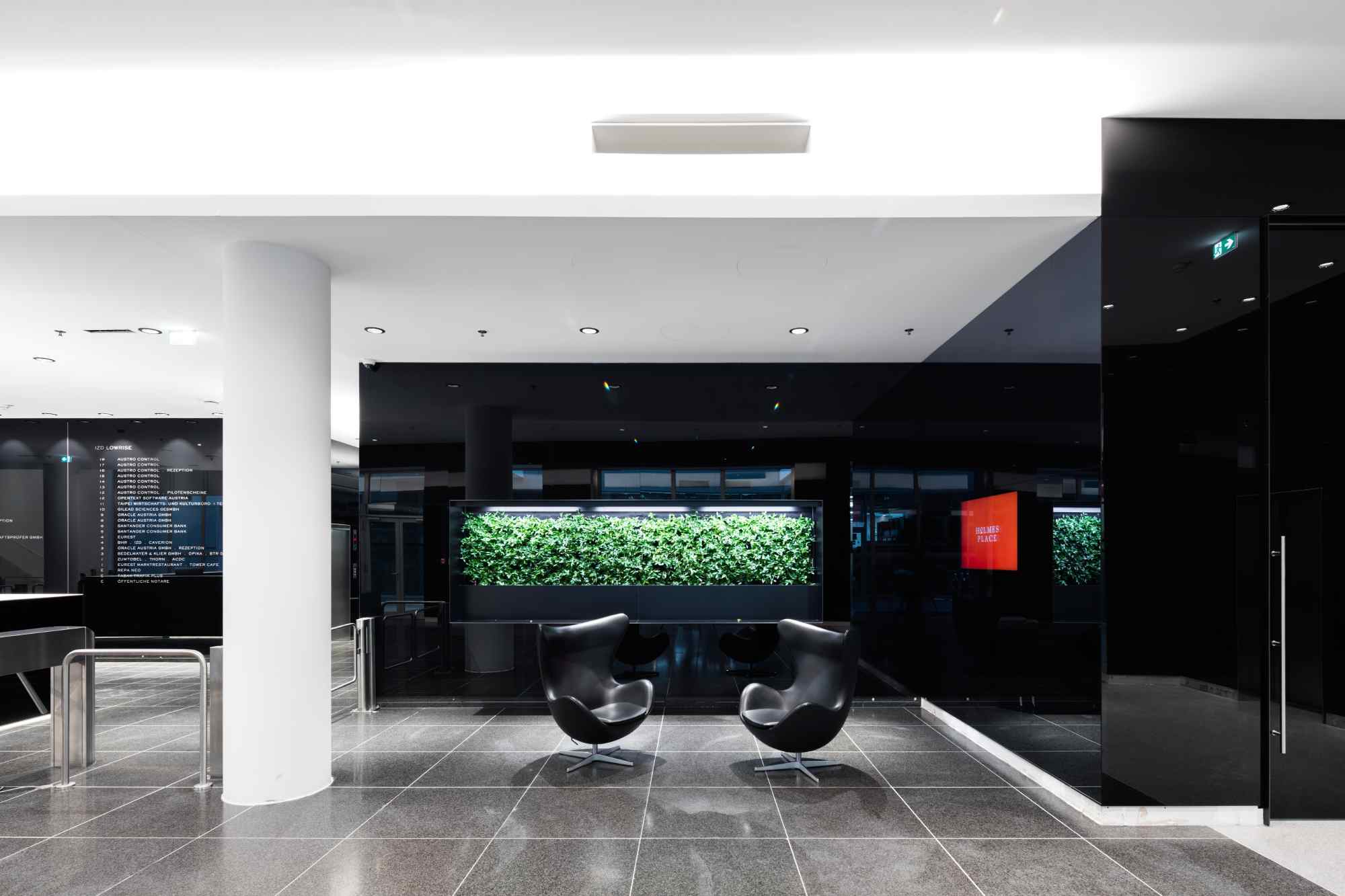 Sitzbereich mit Pflanzenwand im Hintergrund.