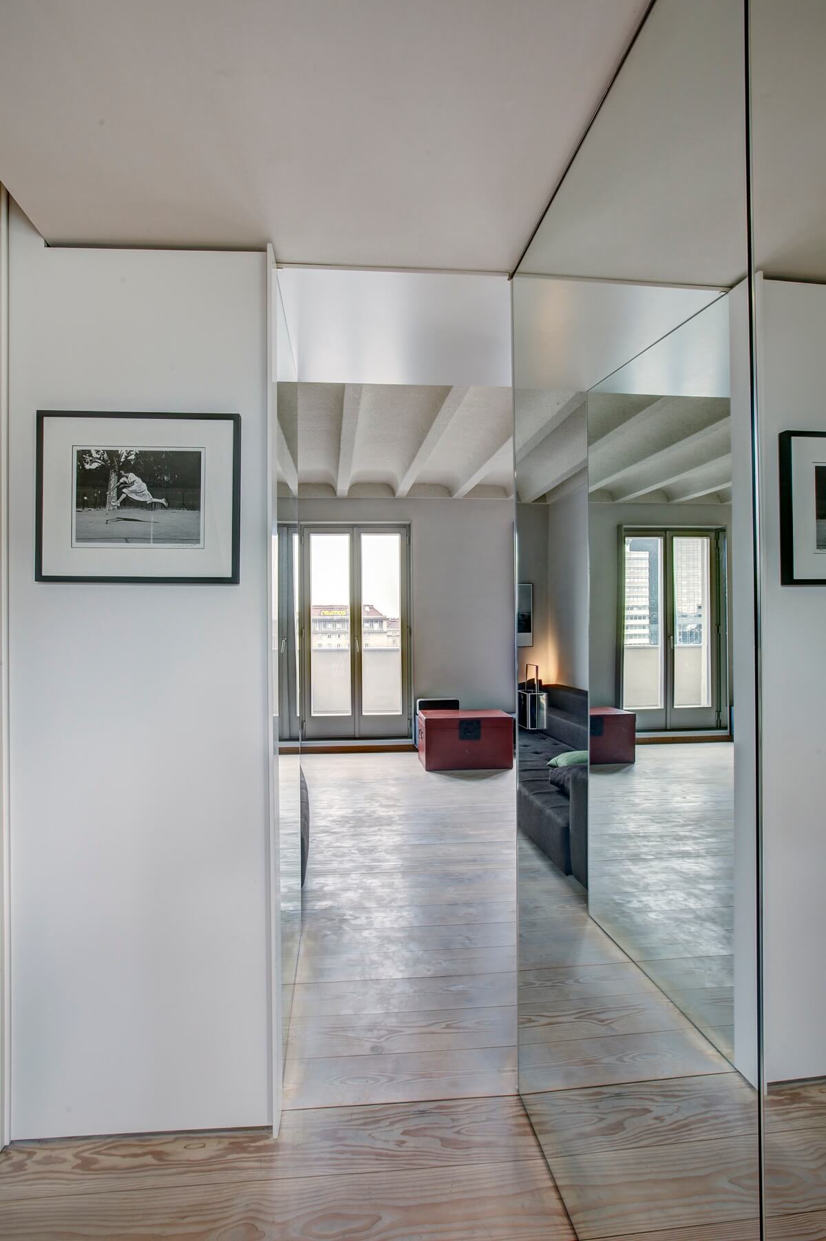 Wohnungsgang mit Kunst an der Wand und hellem Tageslicht.