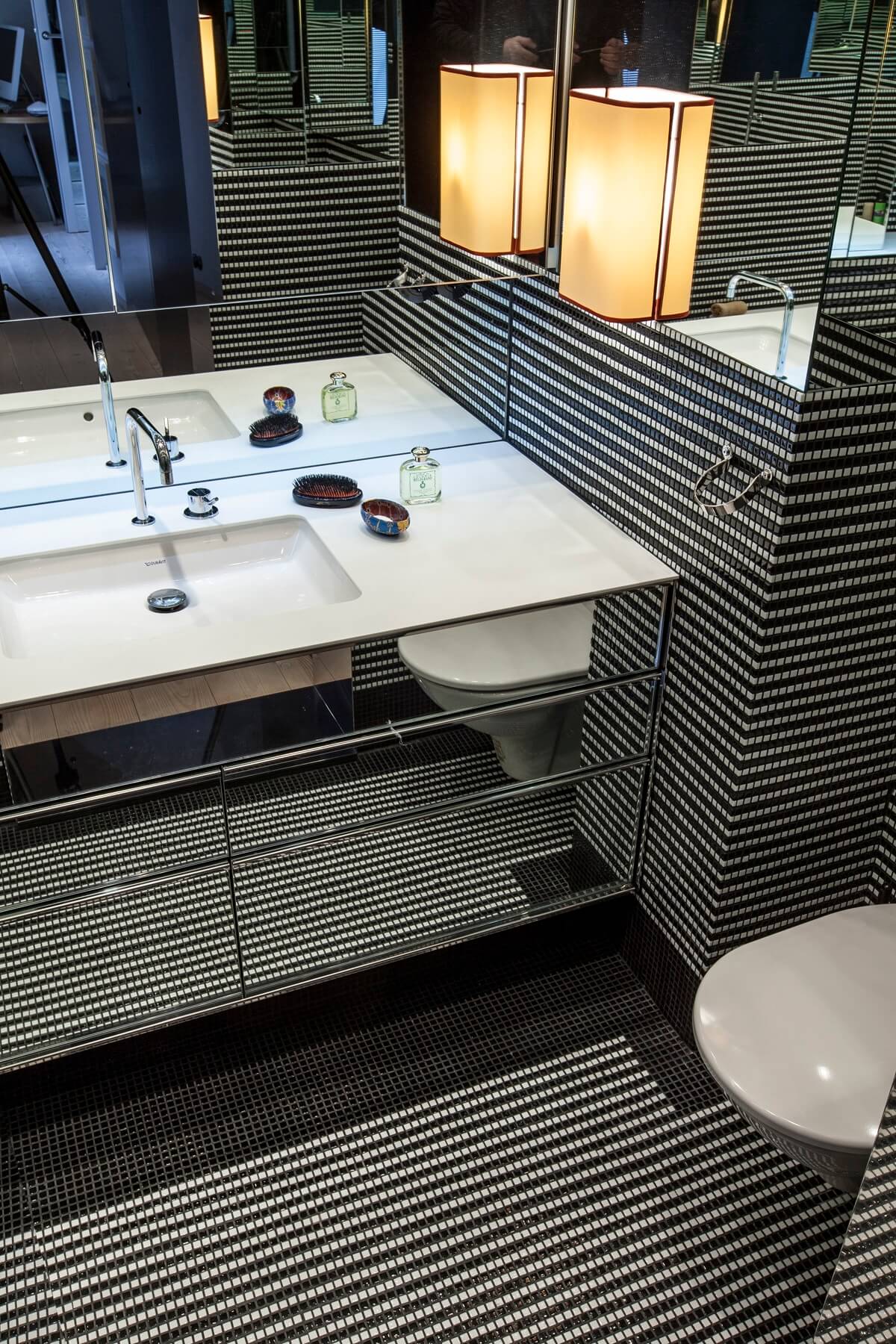 Badezimmer mit Mosaikfliesen und freistehendem Waschbecken.