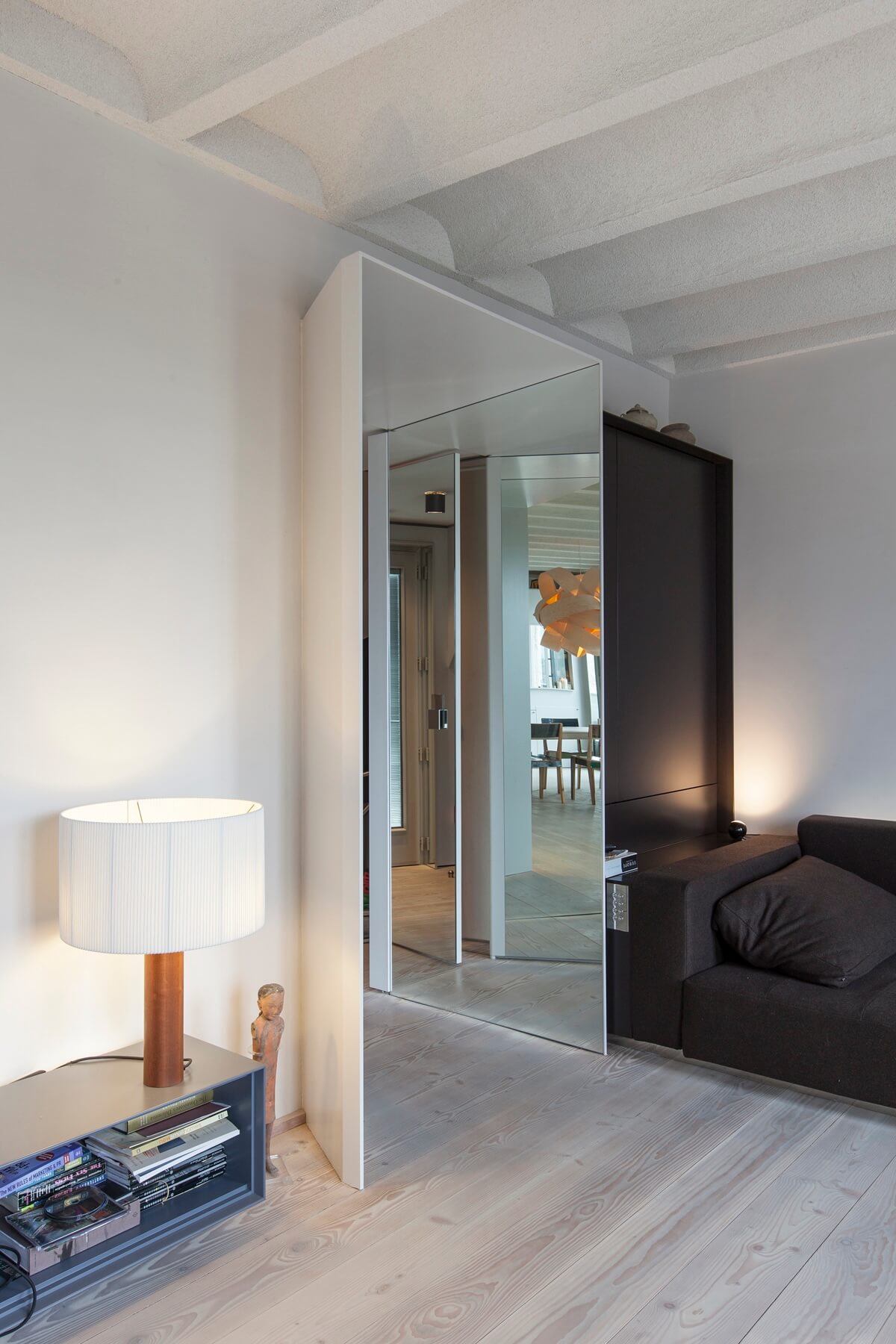 Schlafbereich mit Glaswand und Leselampe.