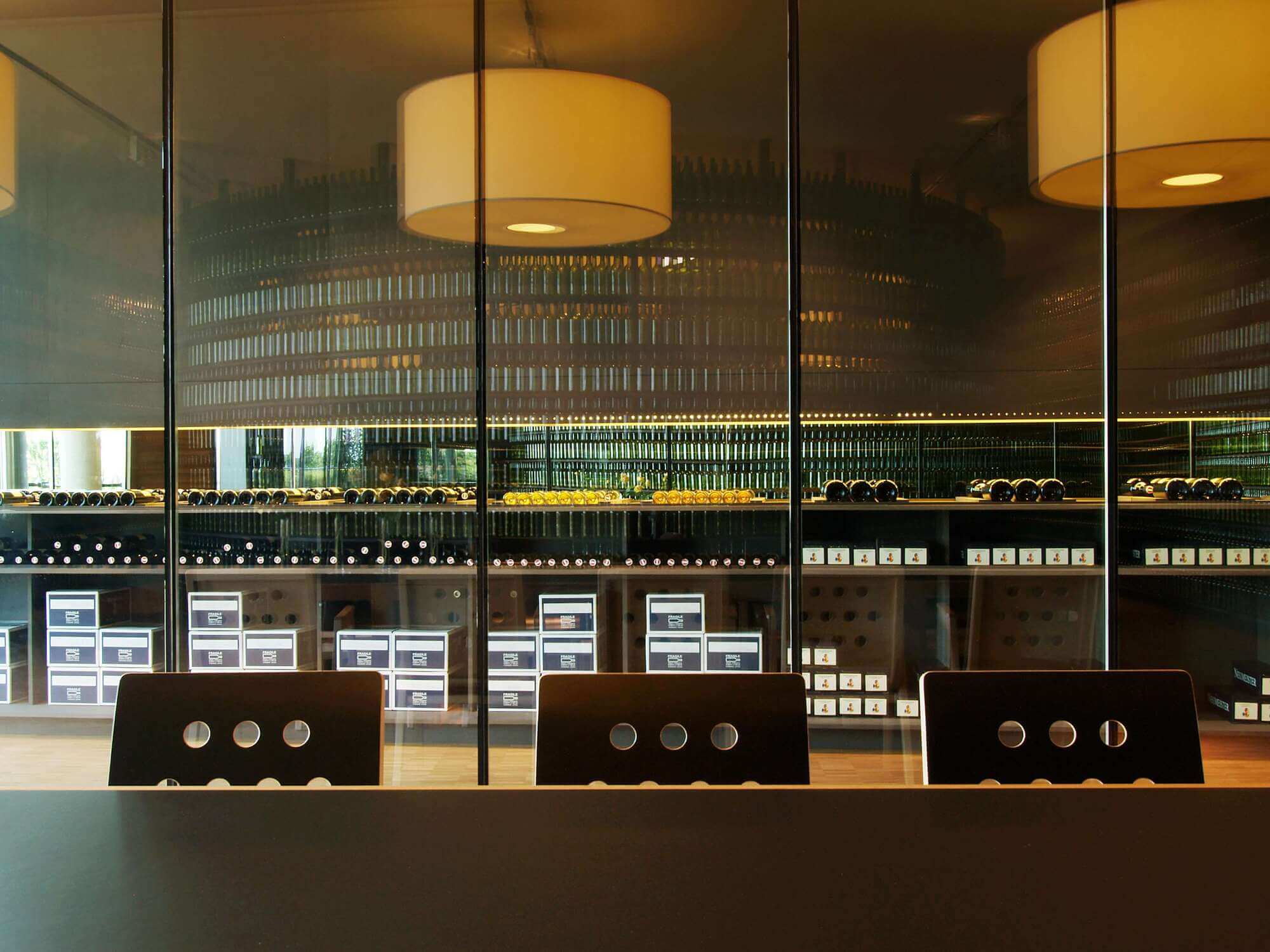 Tisch mit Stühlen und Weinregal im Hintergrund