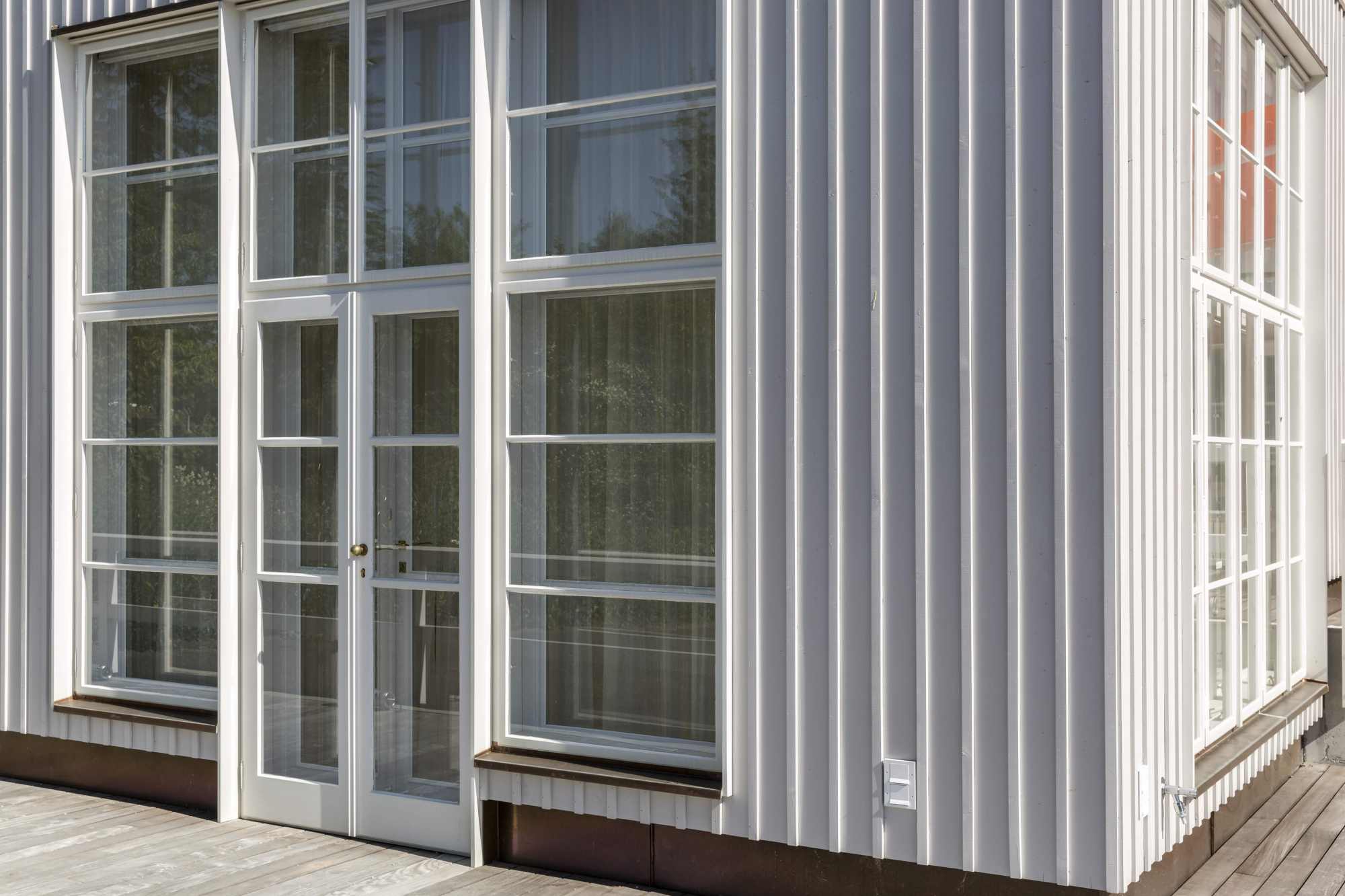 Nahaufnahme der weißen Holzfassade mit Glasdetails