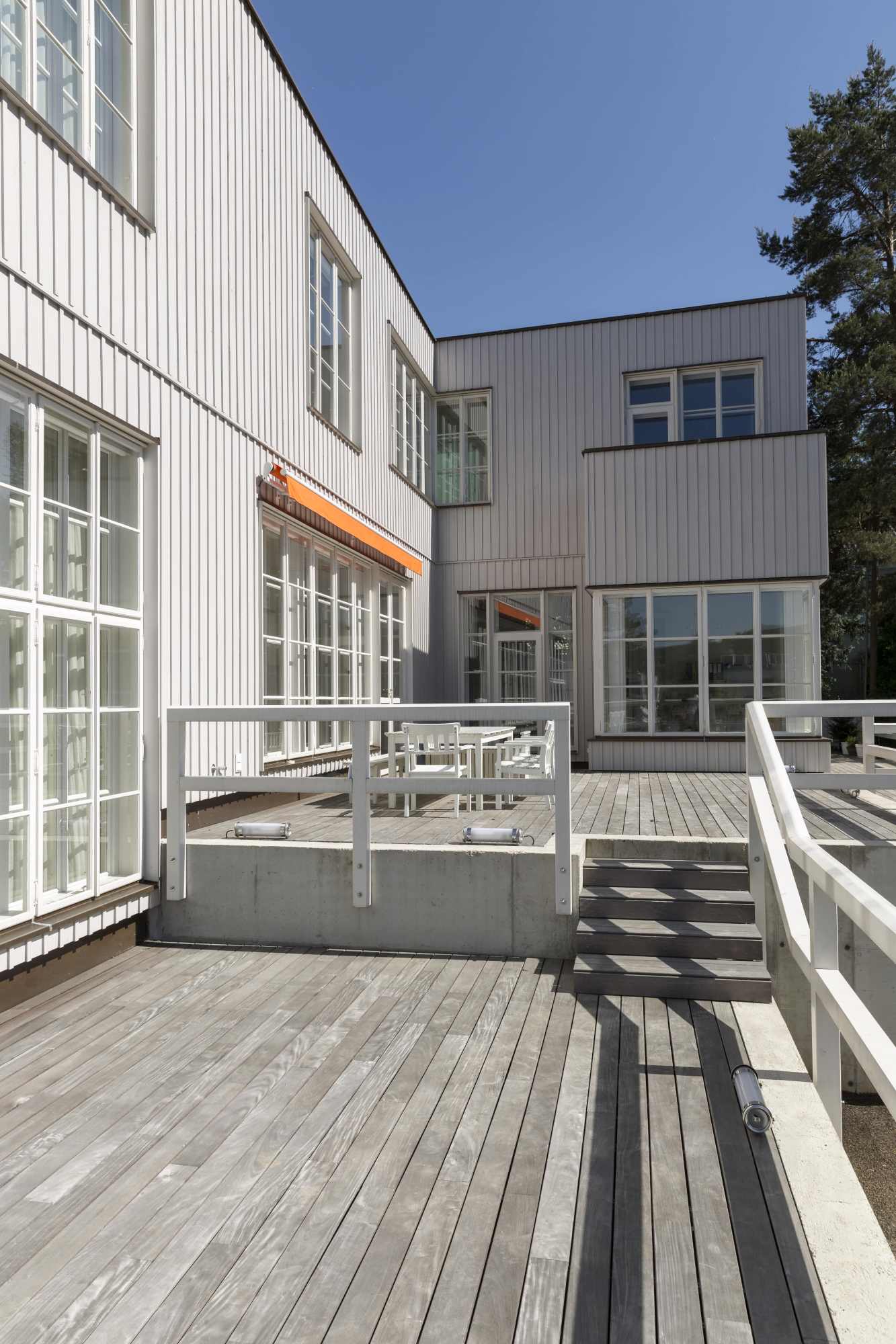 Sonnenterrasse mit Holzboden und weißem Geländer