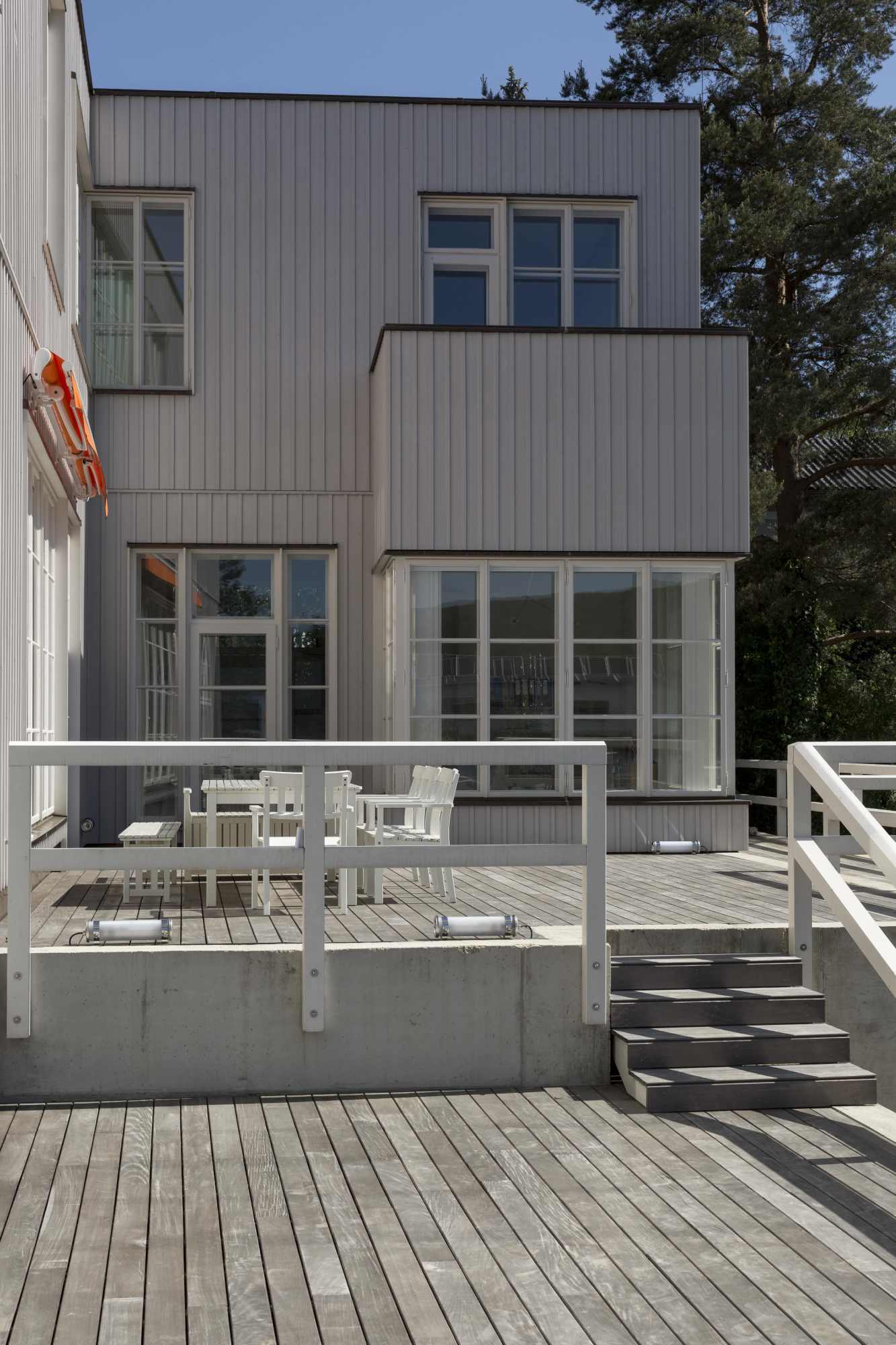 Gartenblick auf Villa mit Glasfassade und Terrasse