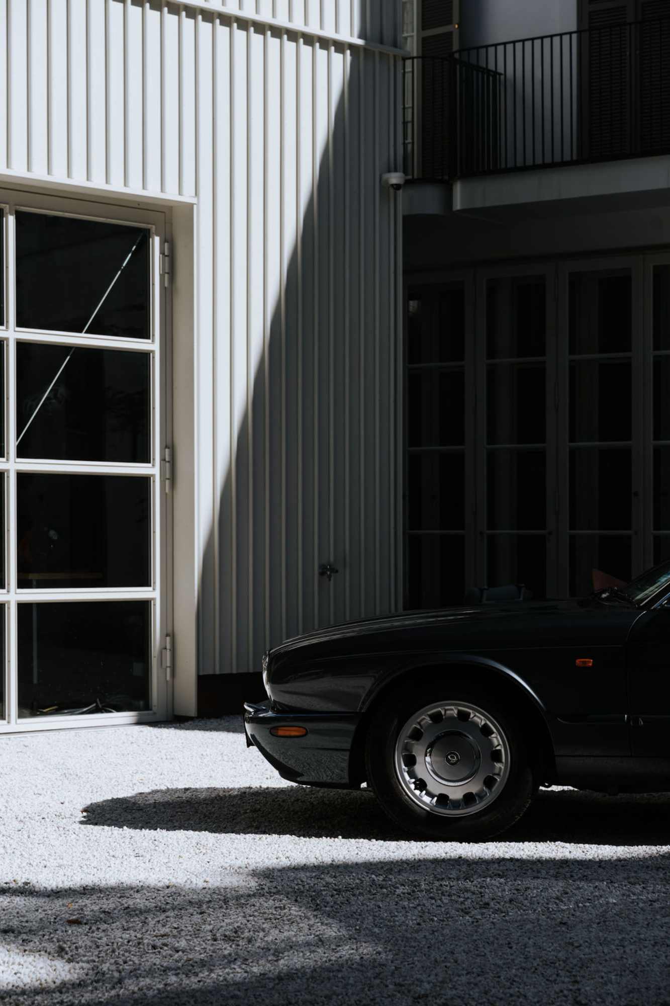 Hausfassade mit Glasfront und geparktem Auto