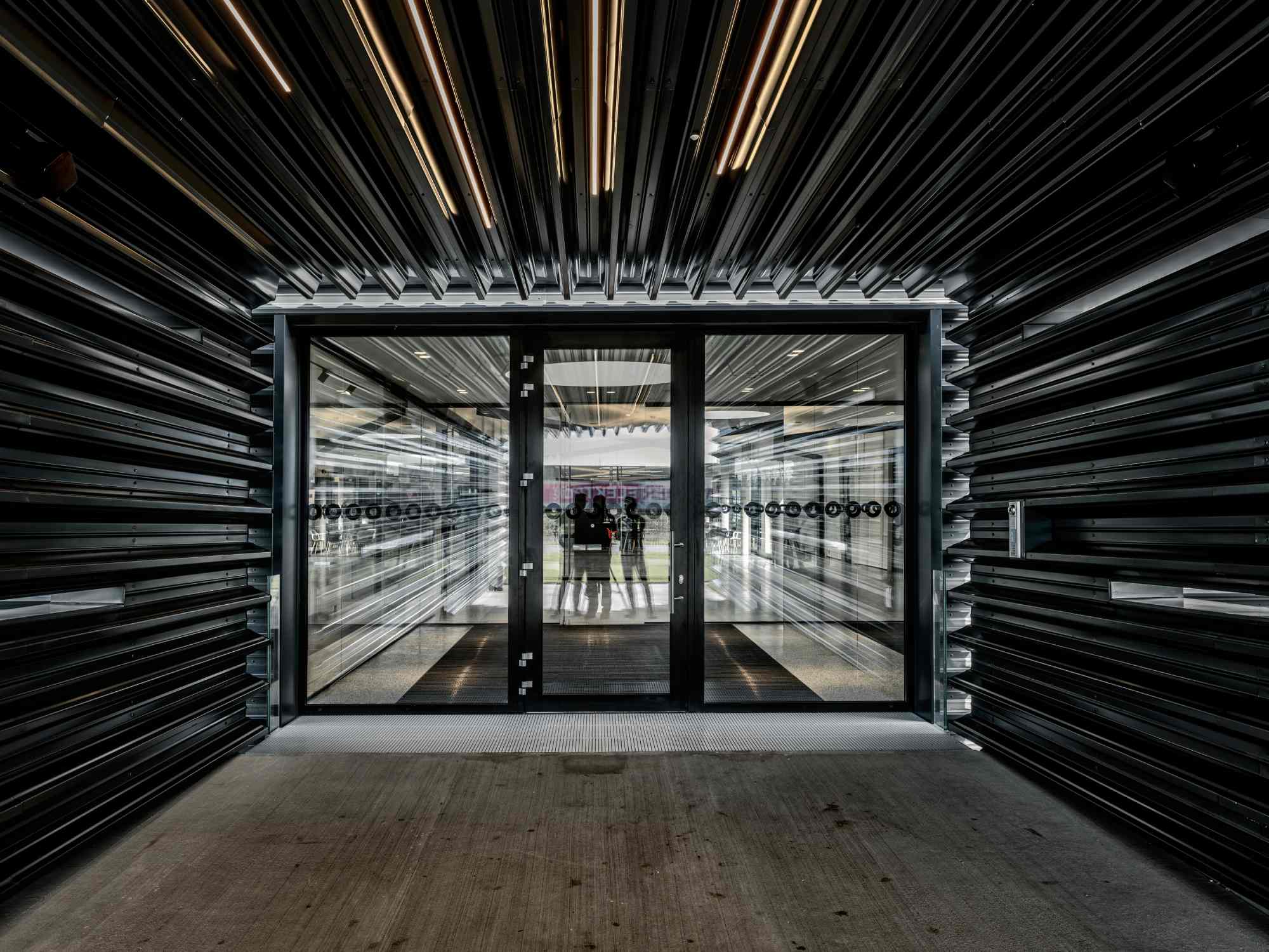 Blick auf ein Eingangsportal mit symmetrischer Lamellenstruktur.