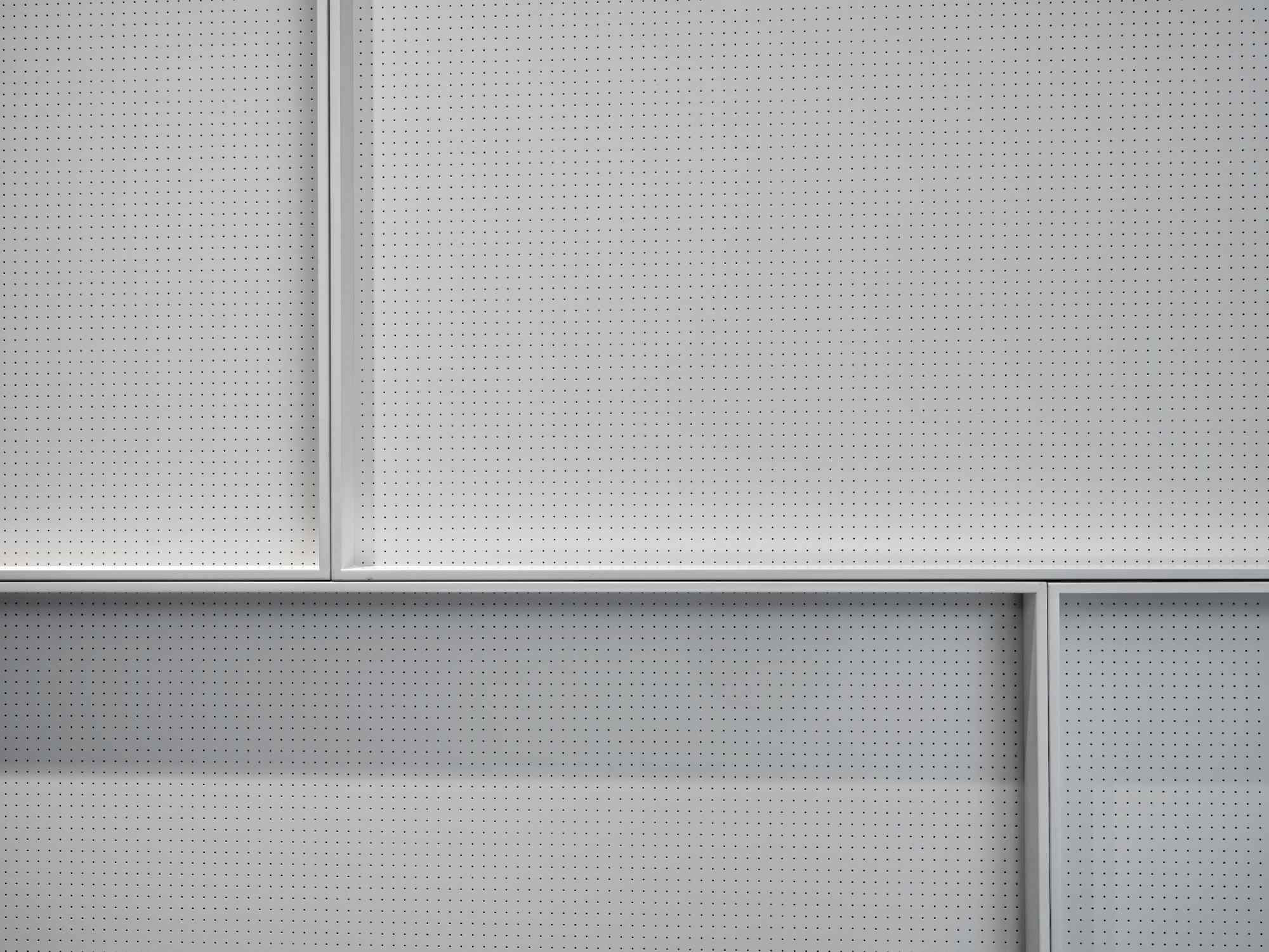 Strukturierte weiße Wand mit klaren Linien und Schatten.