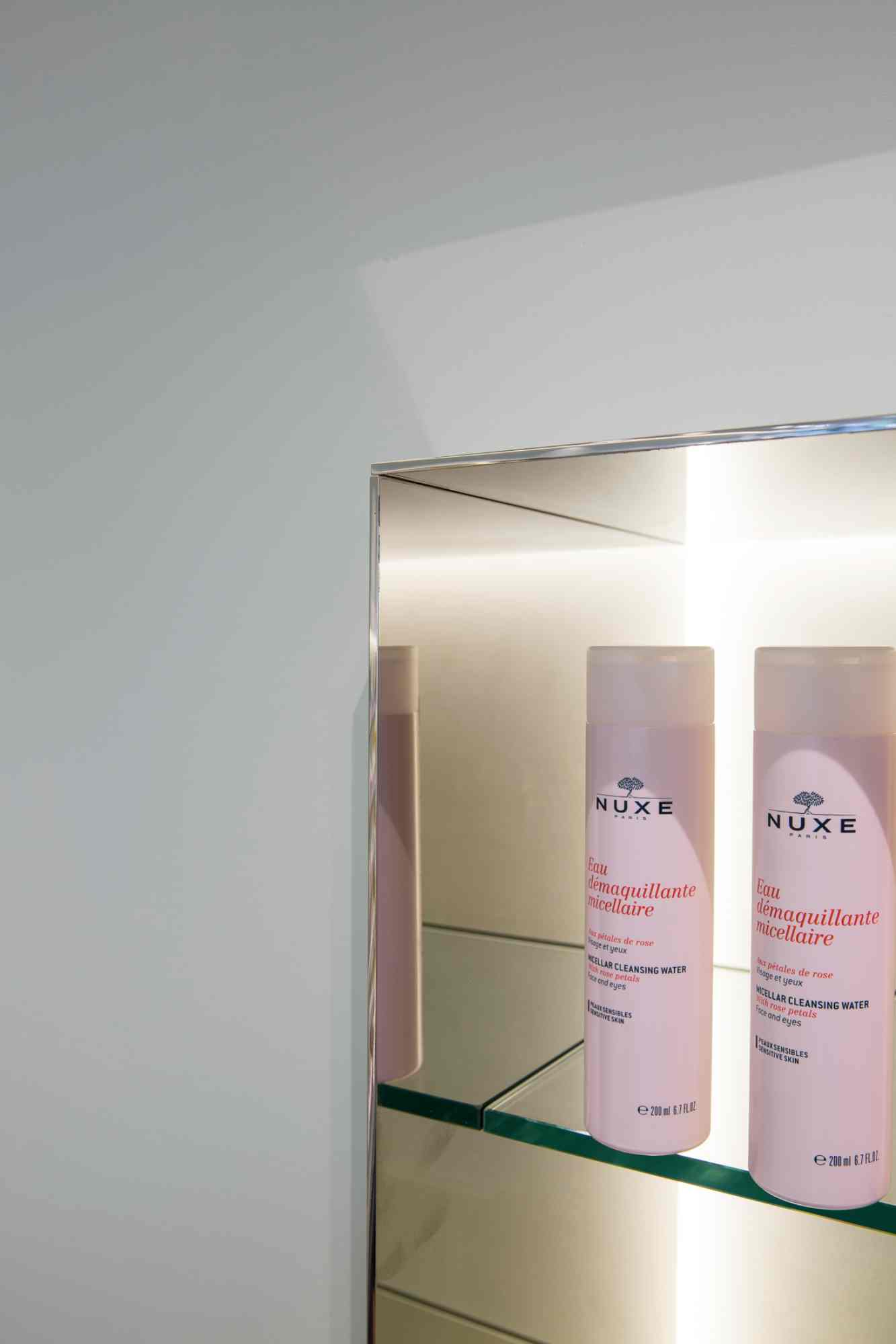 Detail einer Glasvitrine mit Kosmetikprodukten.