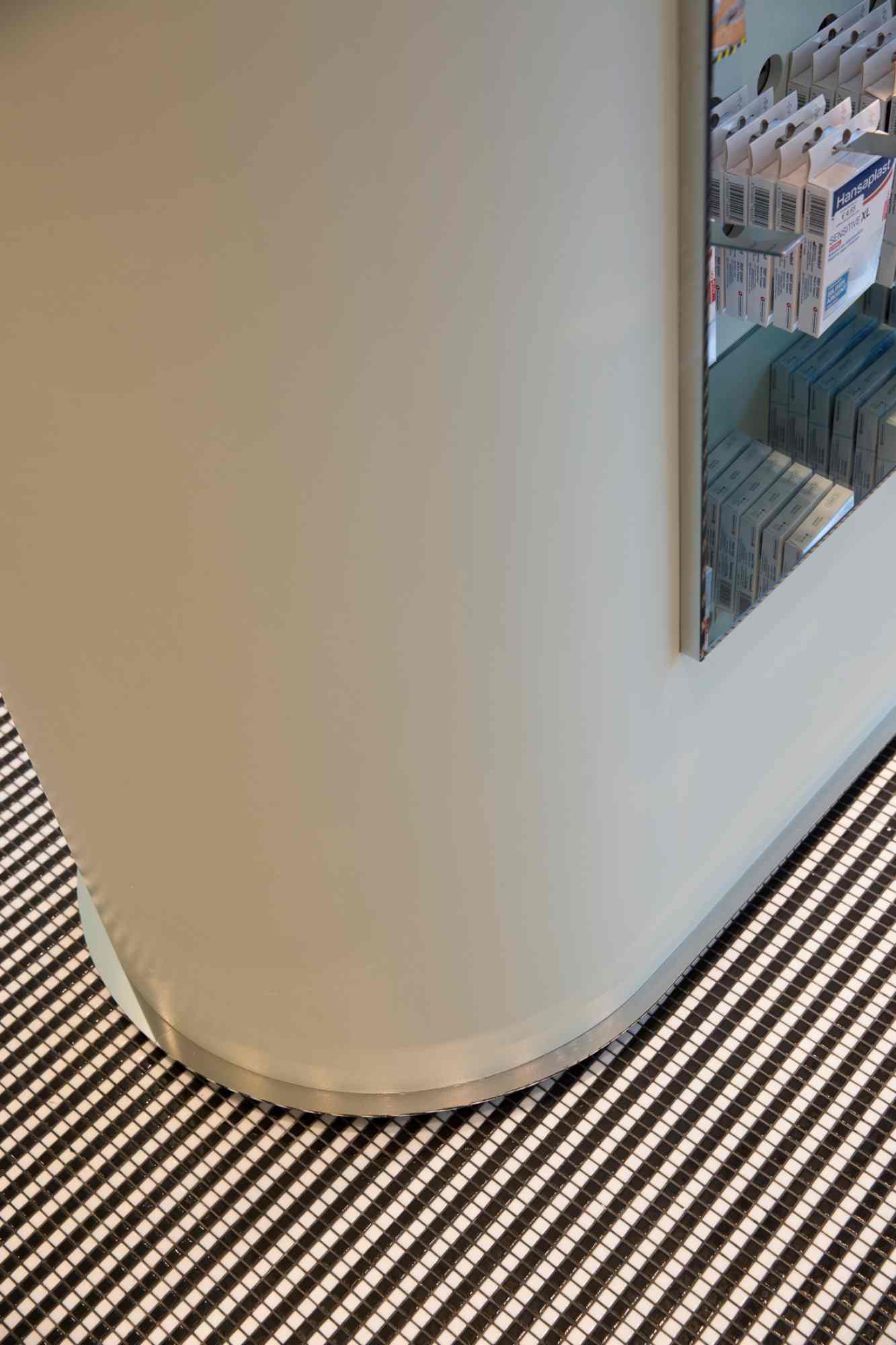 Detailaufnahme eines modernen Metallgitters an Wandrundung  im Eingangsbereich der Apotheke