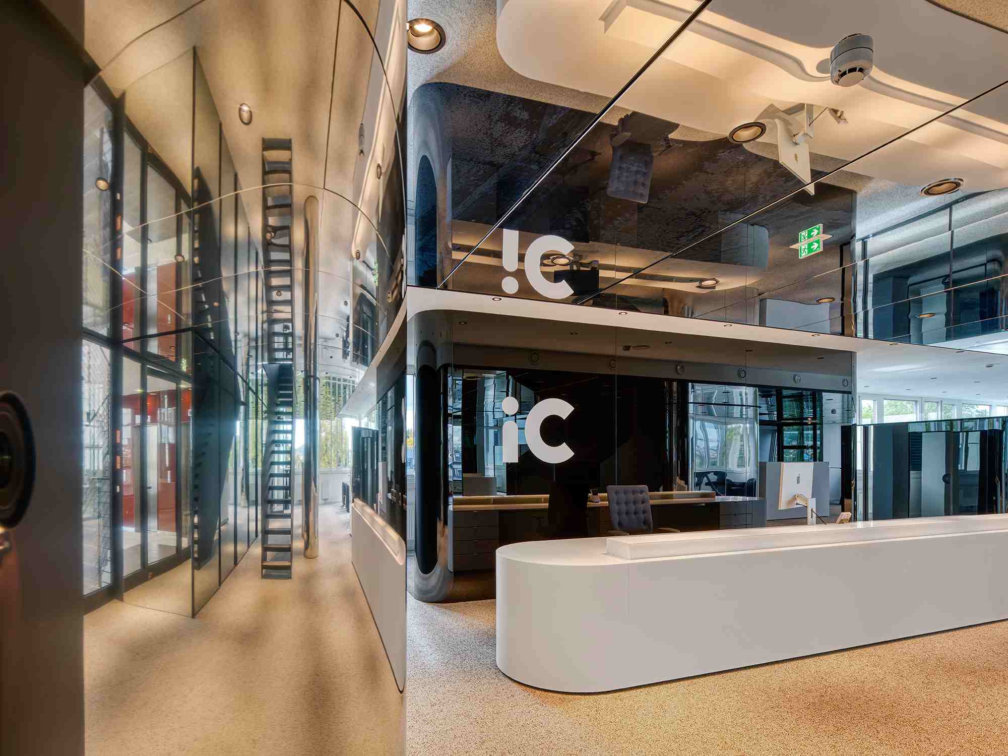 Modernes Bürogebäude mit glänzenden Glasflächen, Empfangsbereich und futuristischem Design im IC Office.
