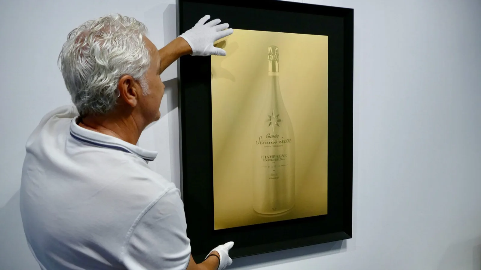 A finished NAUBLÉ gold artwork being mounted on the gallery wall