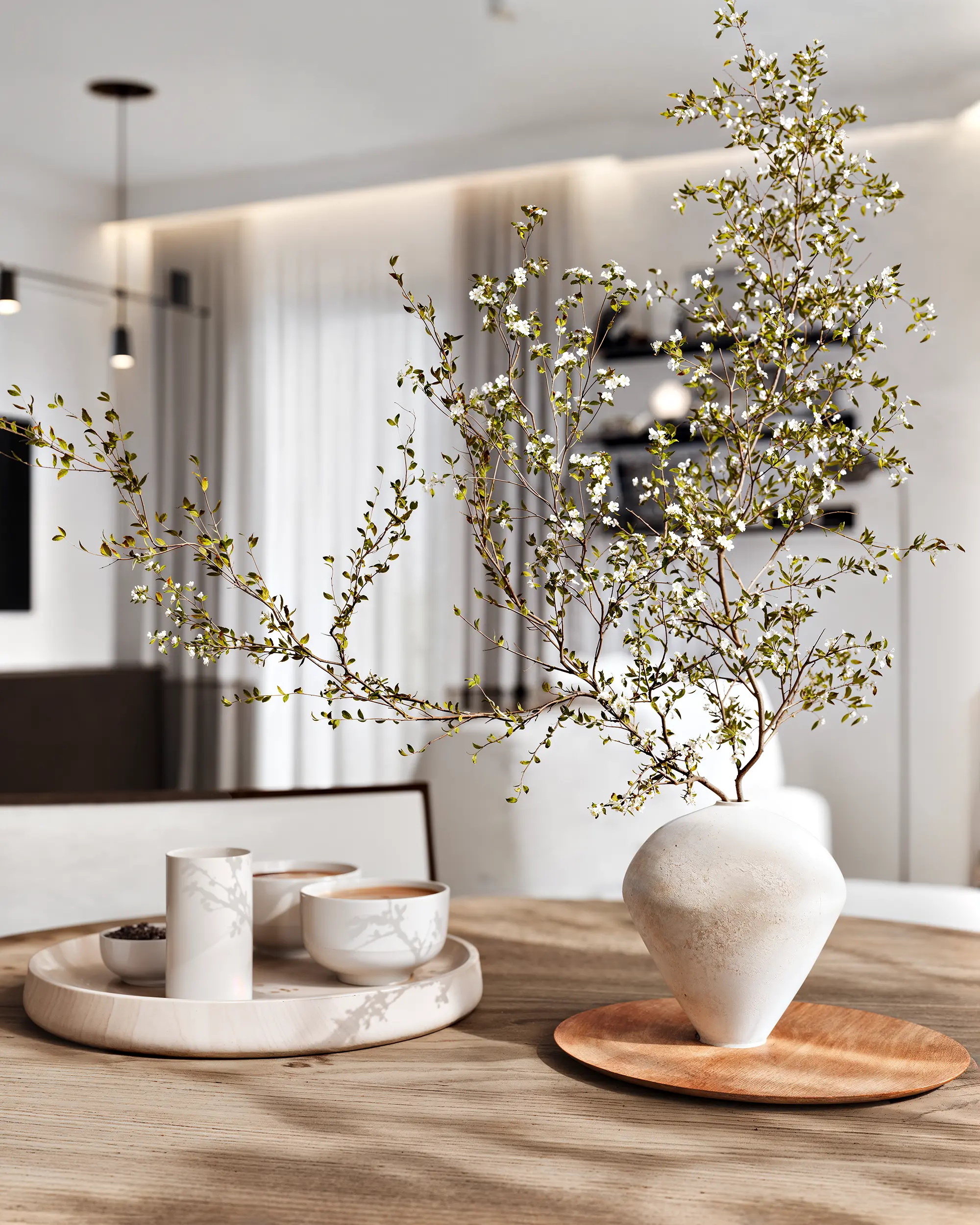 Close-up of an elegant tablescape on a dining table, featuring a modern vase and dishes.