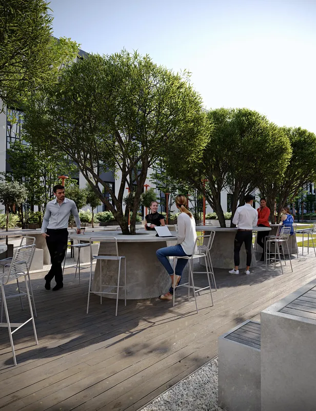 Vibrant outdoor seating area in a park, with people working and relaxing at tables under trees.