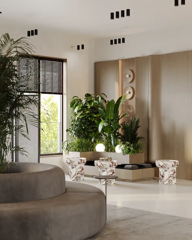 Bright waiting lounge by a window with seating, coffee tables, and a large floral arrangement.