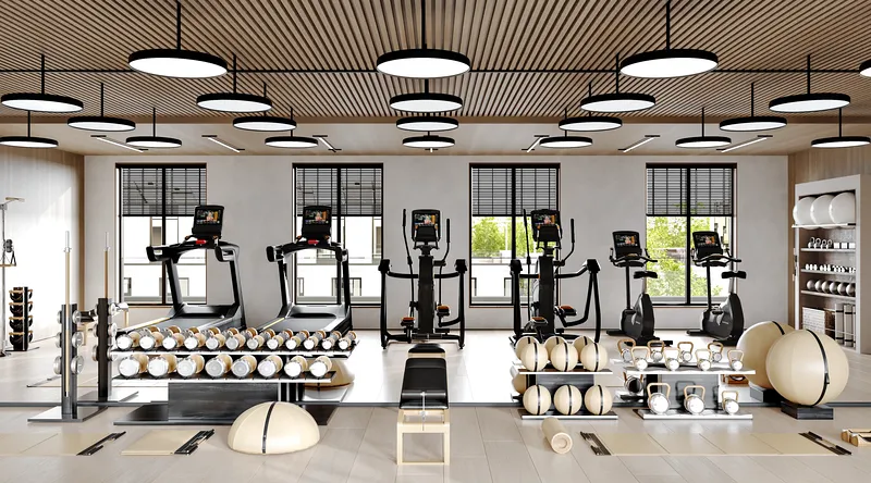 Strength training area with organized racks of dumbbells, kettlebells, and medicine balls by a mirror.